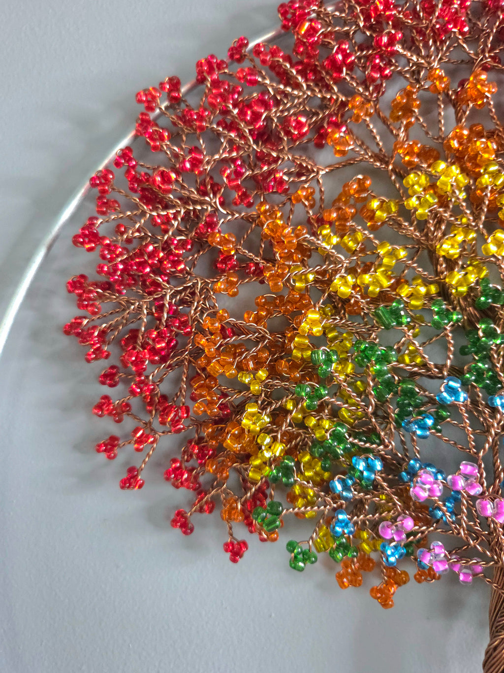 Decorative wall art of a tree with colorful leaves on a plain background