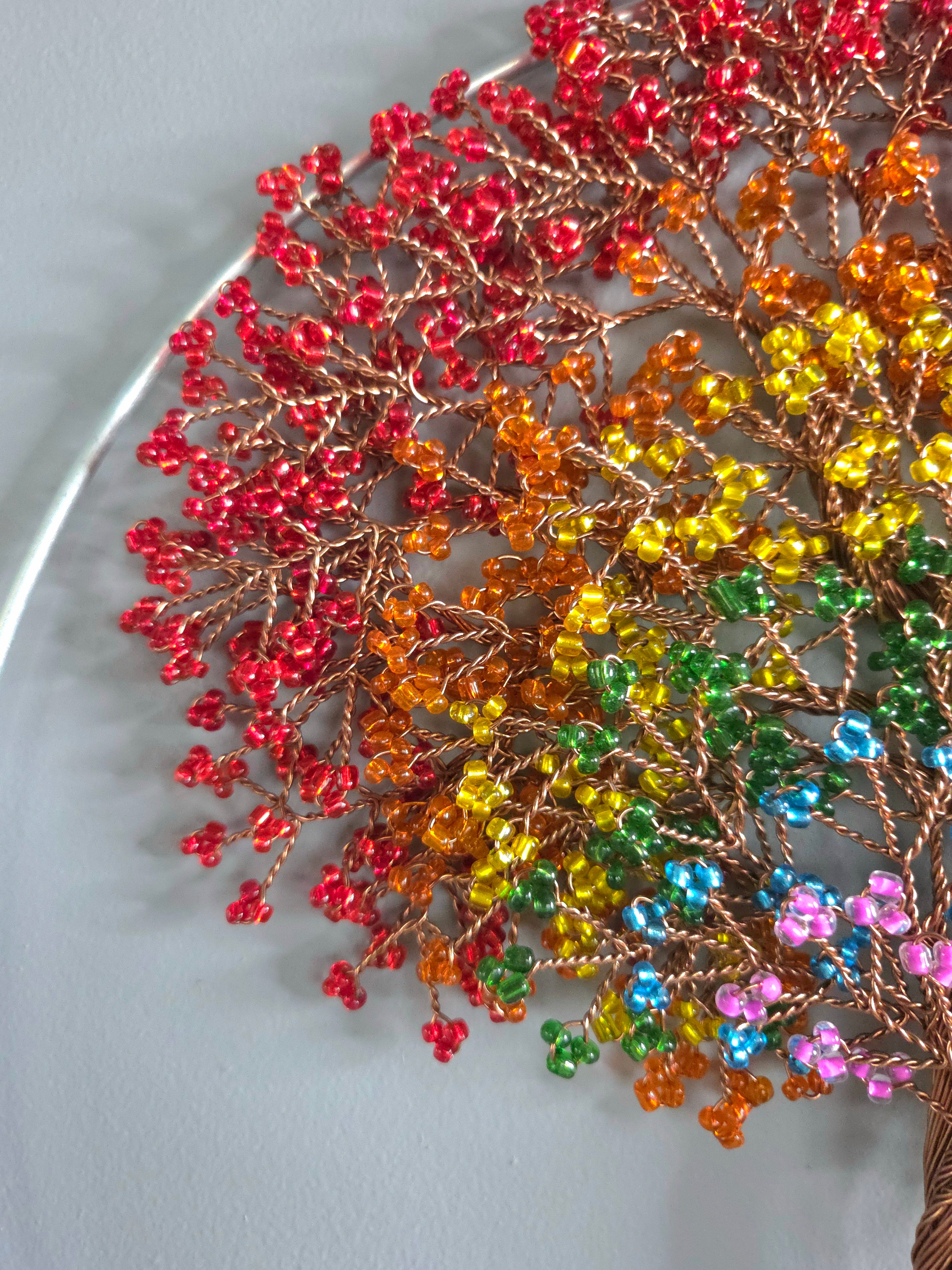 Decorative wall art of a tree with colorful leaves on a plain background