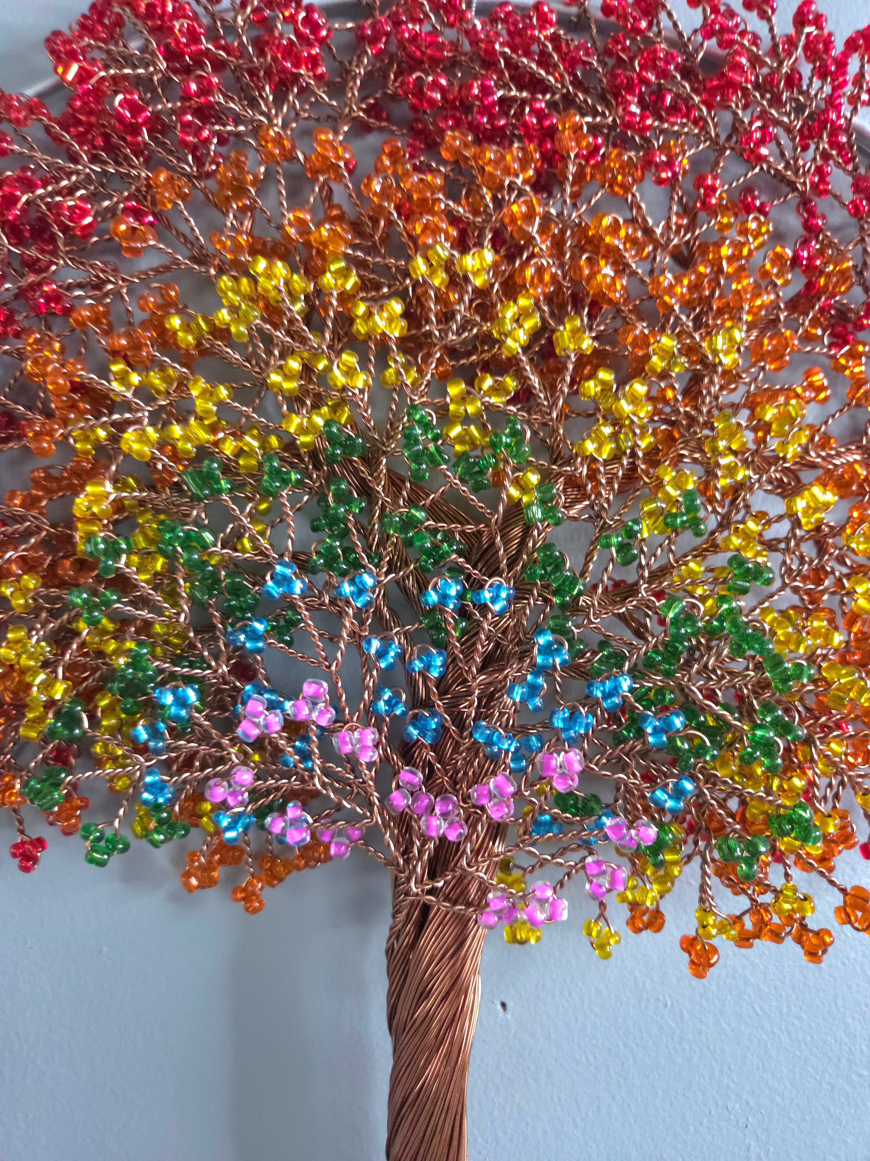 Decorative wall art of a tree with colorful leaves on a plain background