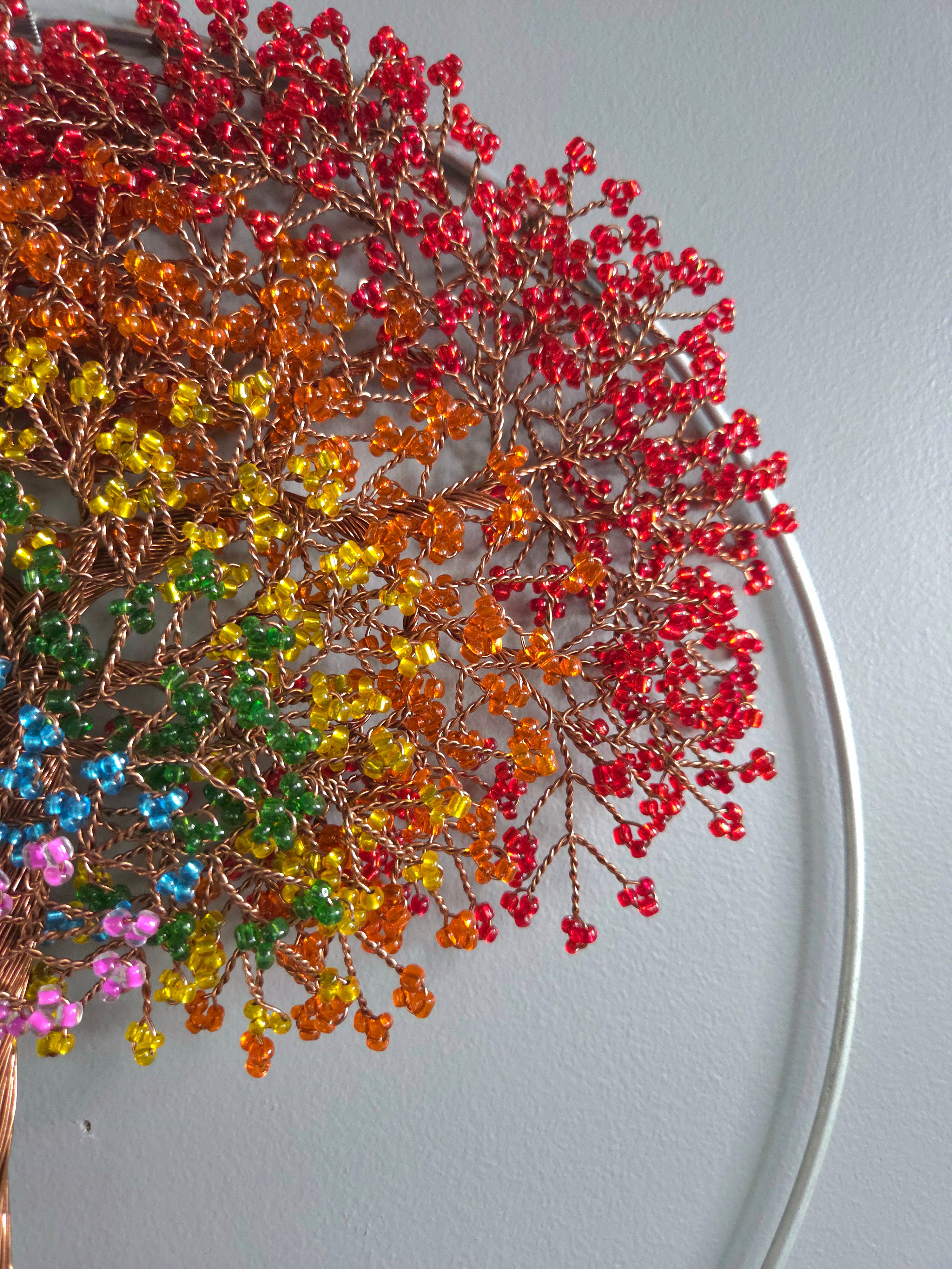 Decorative wall art of a tree with colorful leaves on a plain background