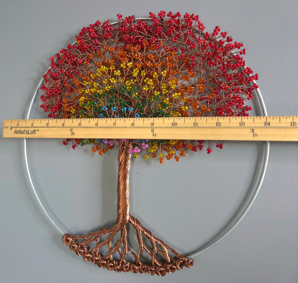 Decorative wall art of a tree with colorful leaves on a plain background