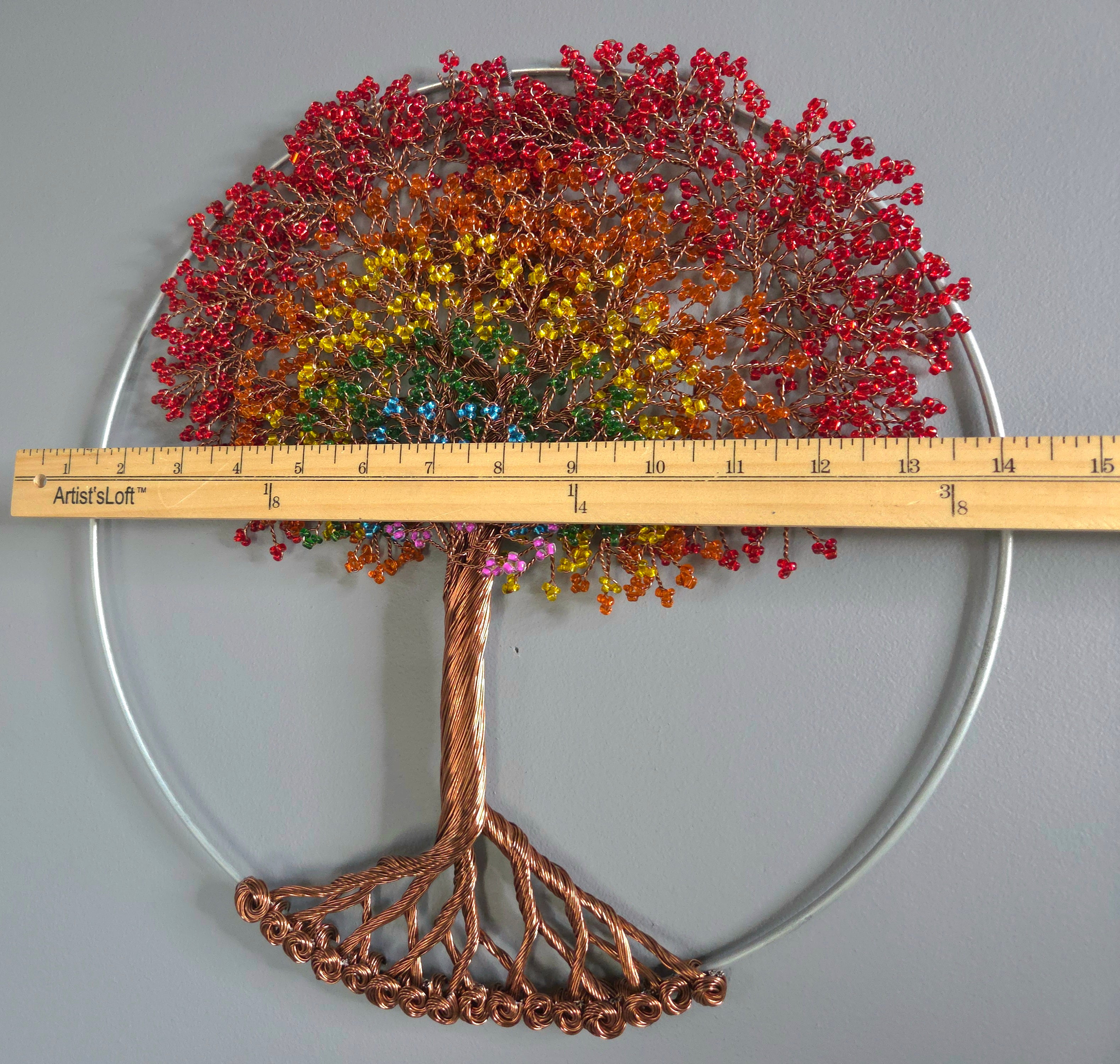 Decorative wall art of a tree with colorful leaves on a plain background