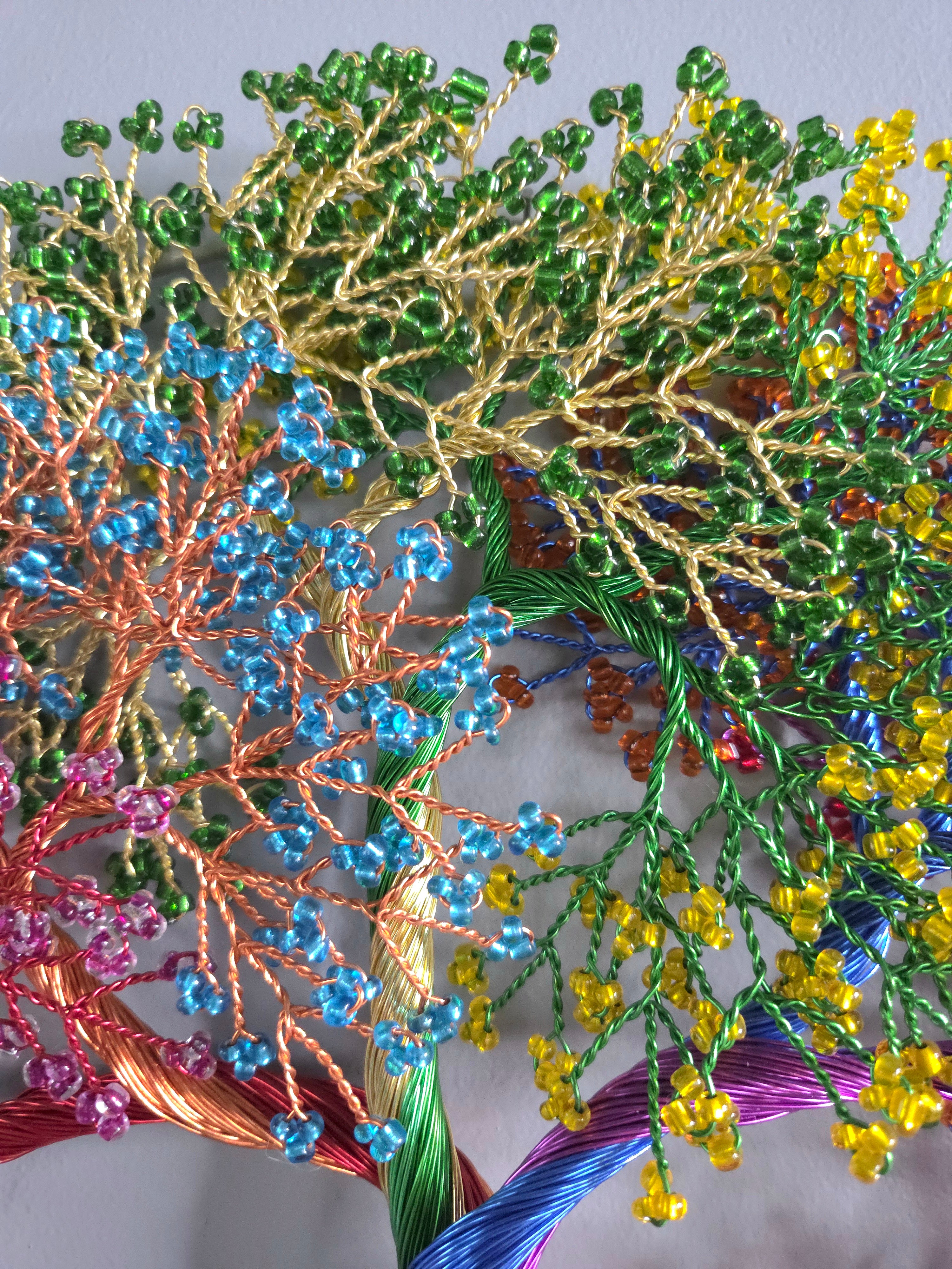 Close-up of colorful beaded and embroidered floral design on fabric.