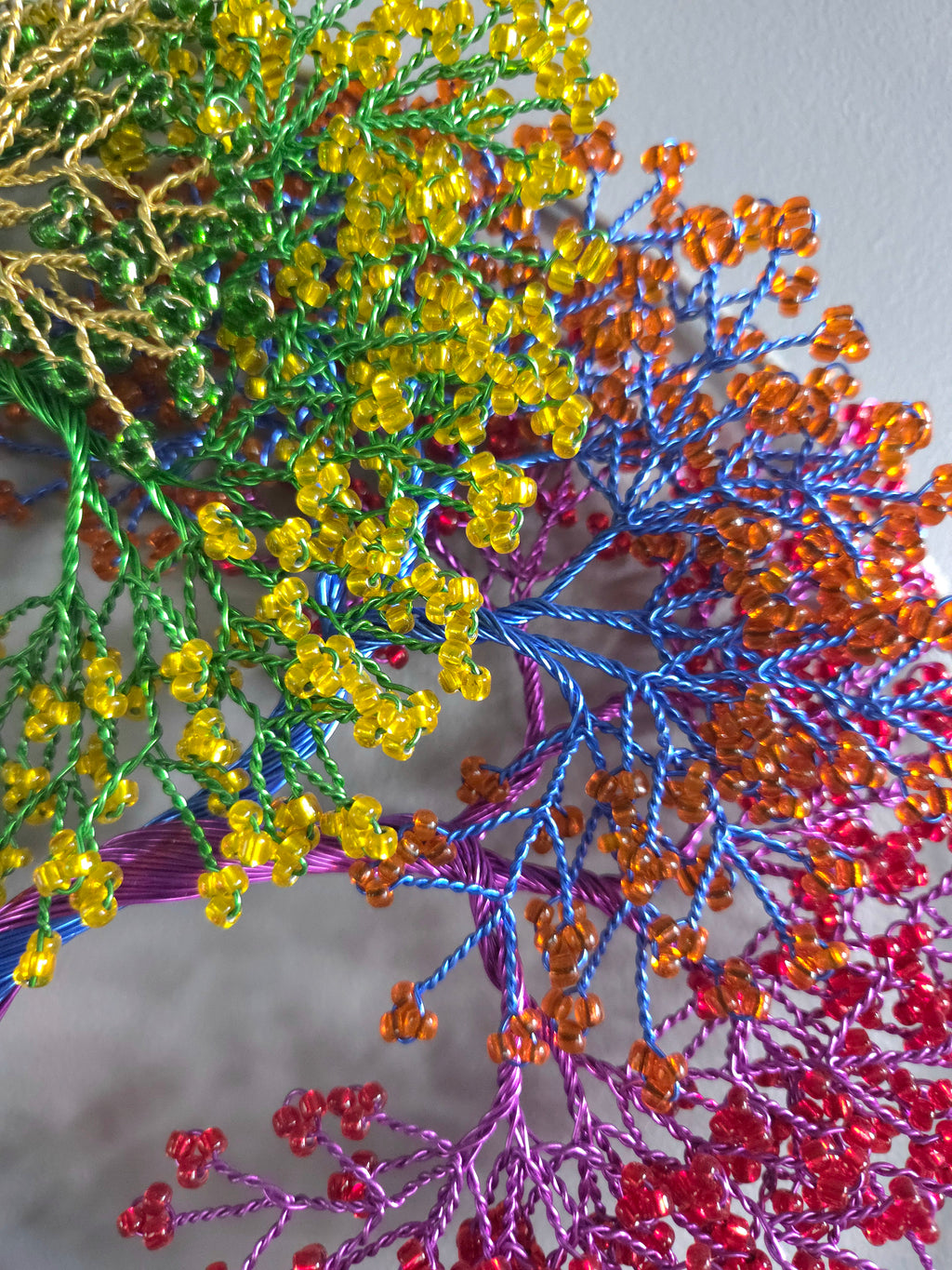 Close-up of colorful beaded branches with a blurred background