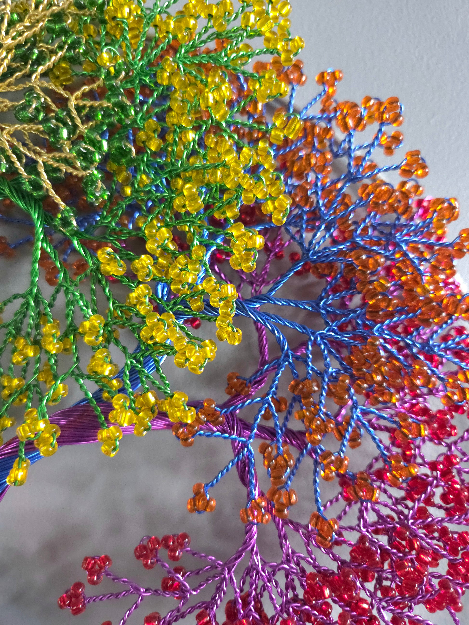 Close-up of colorful beaded branches with a blurred background