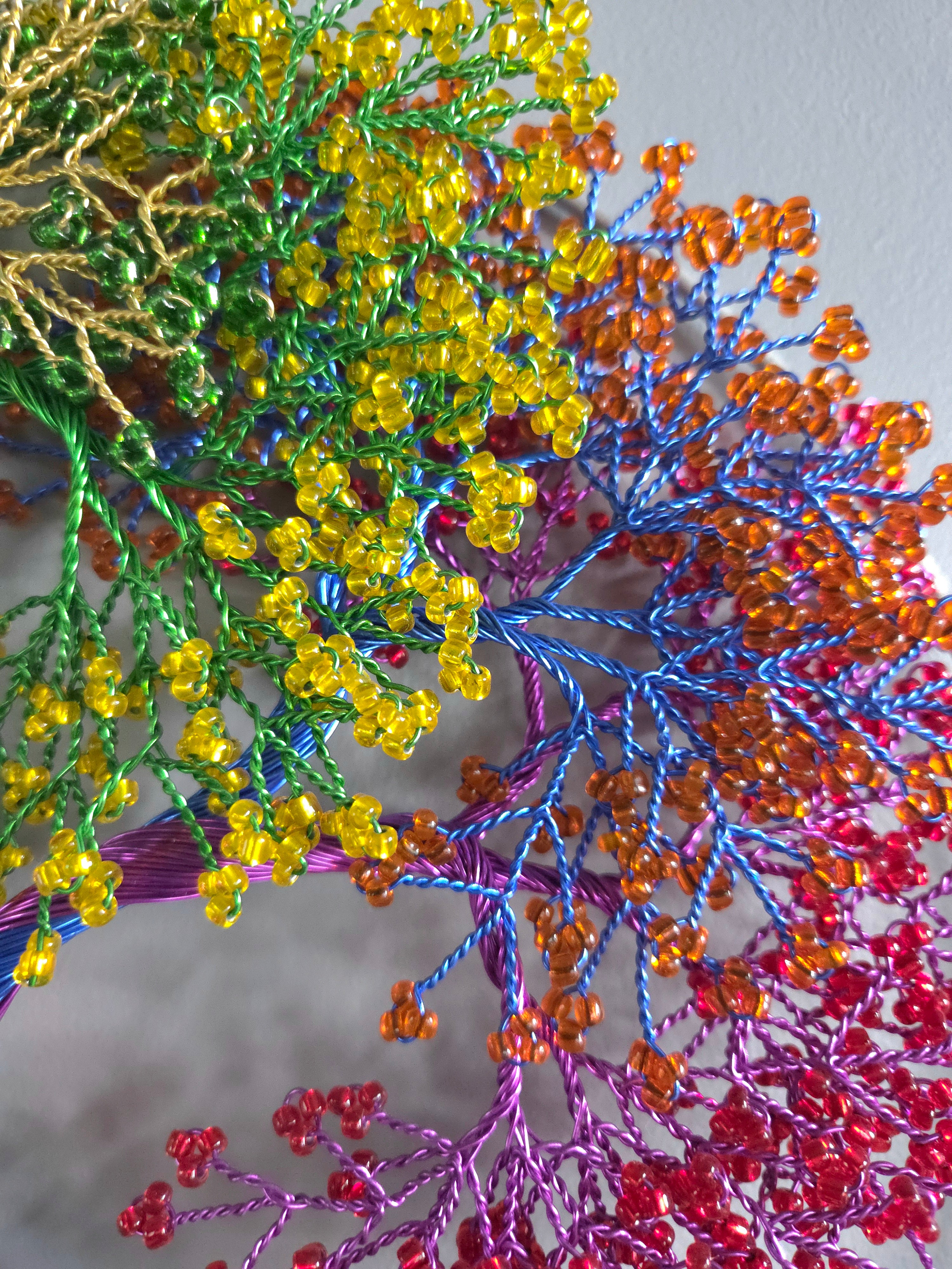 Close-up of colorful beaded branches with a blurred background