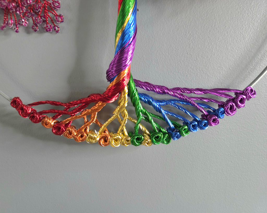 Colorful braided necklace on a light gray background