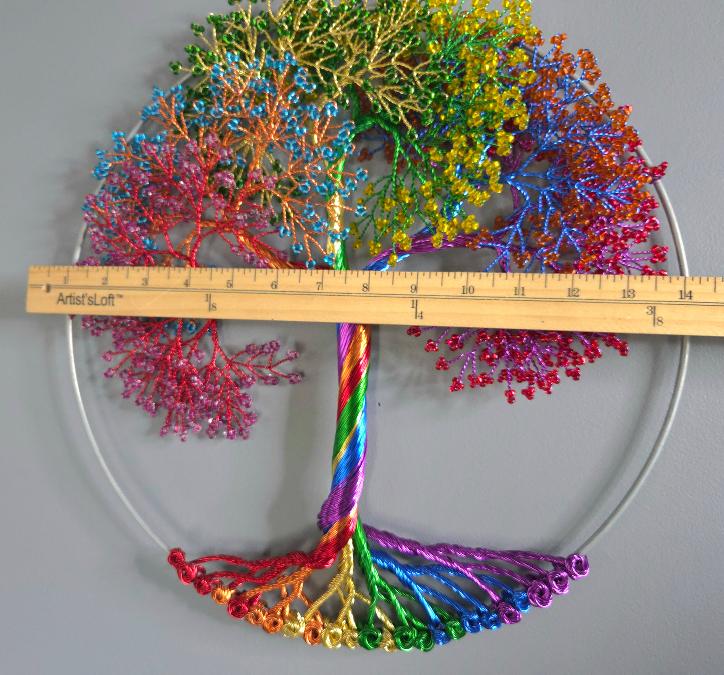 Colorful coral-like structure with a ruler for scale on a gray background