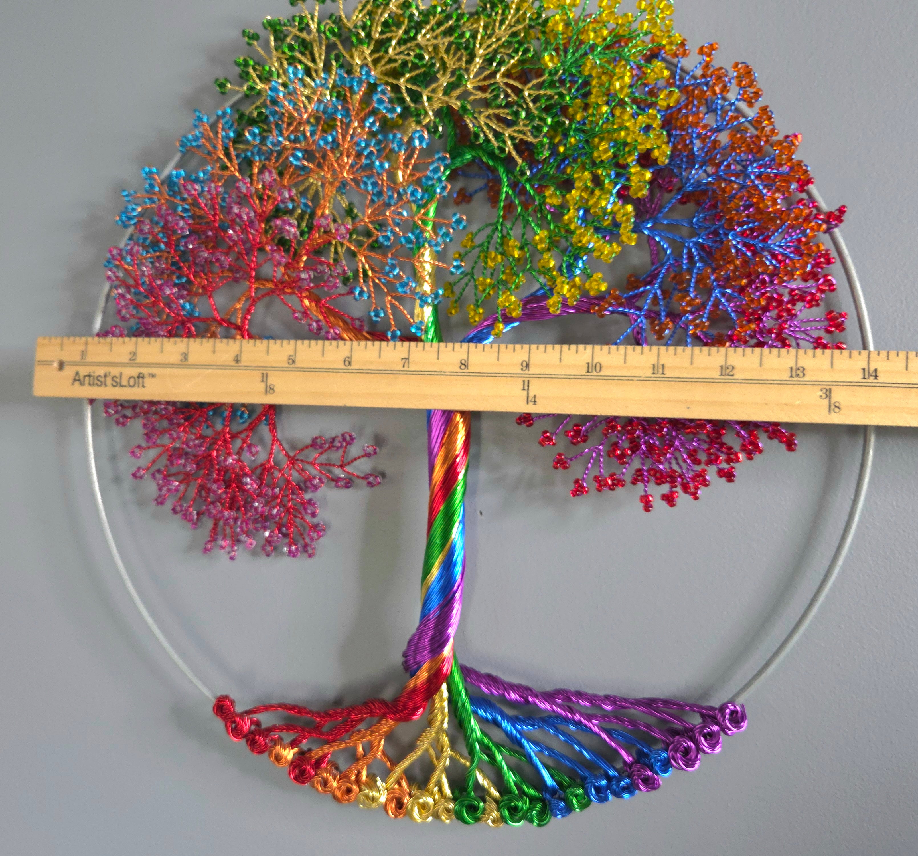 Colorful coral-like structure with a ruler for scale on a gray background