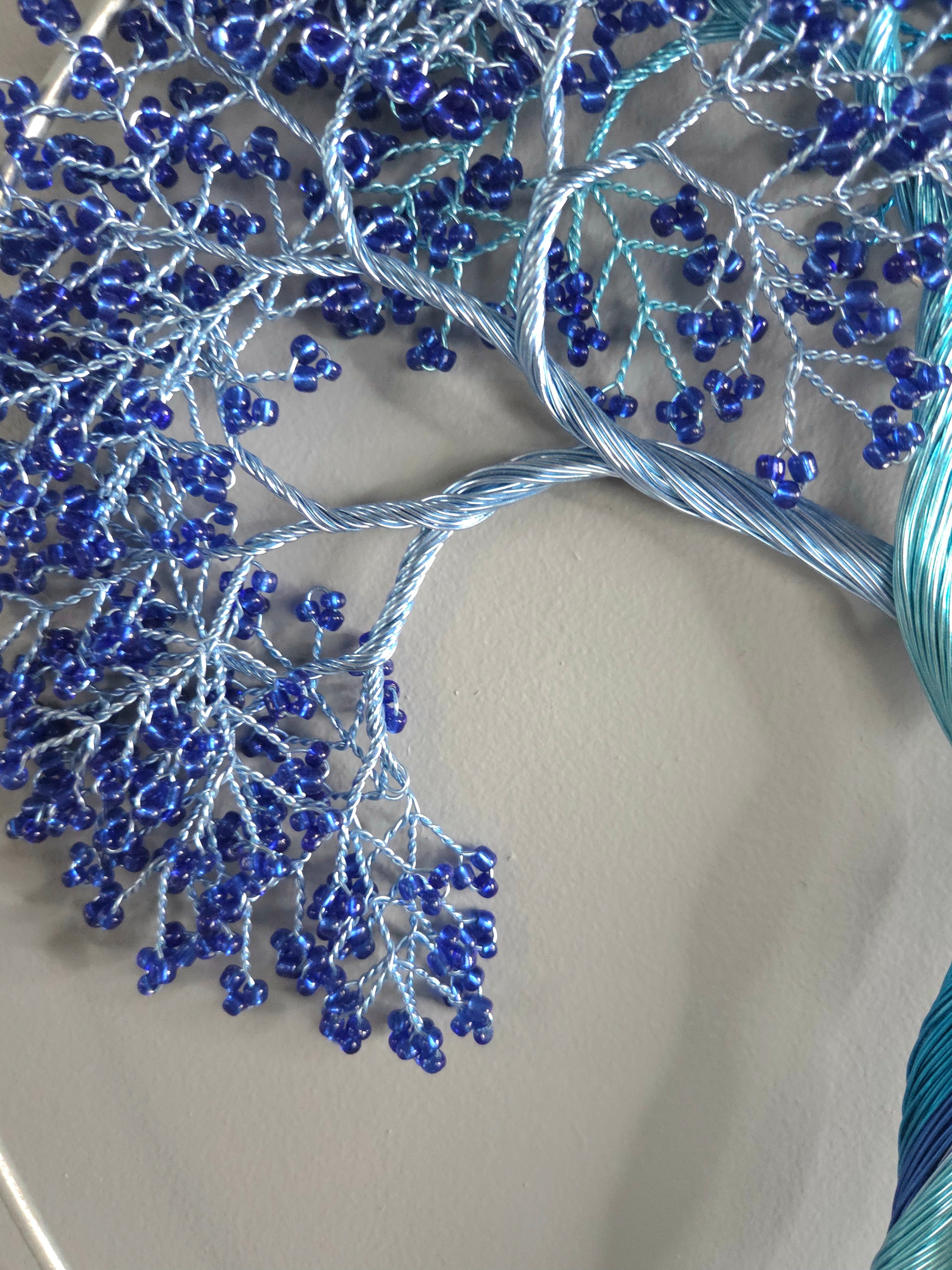 Decorative wall art of a tree with blue branches on a gray background