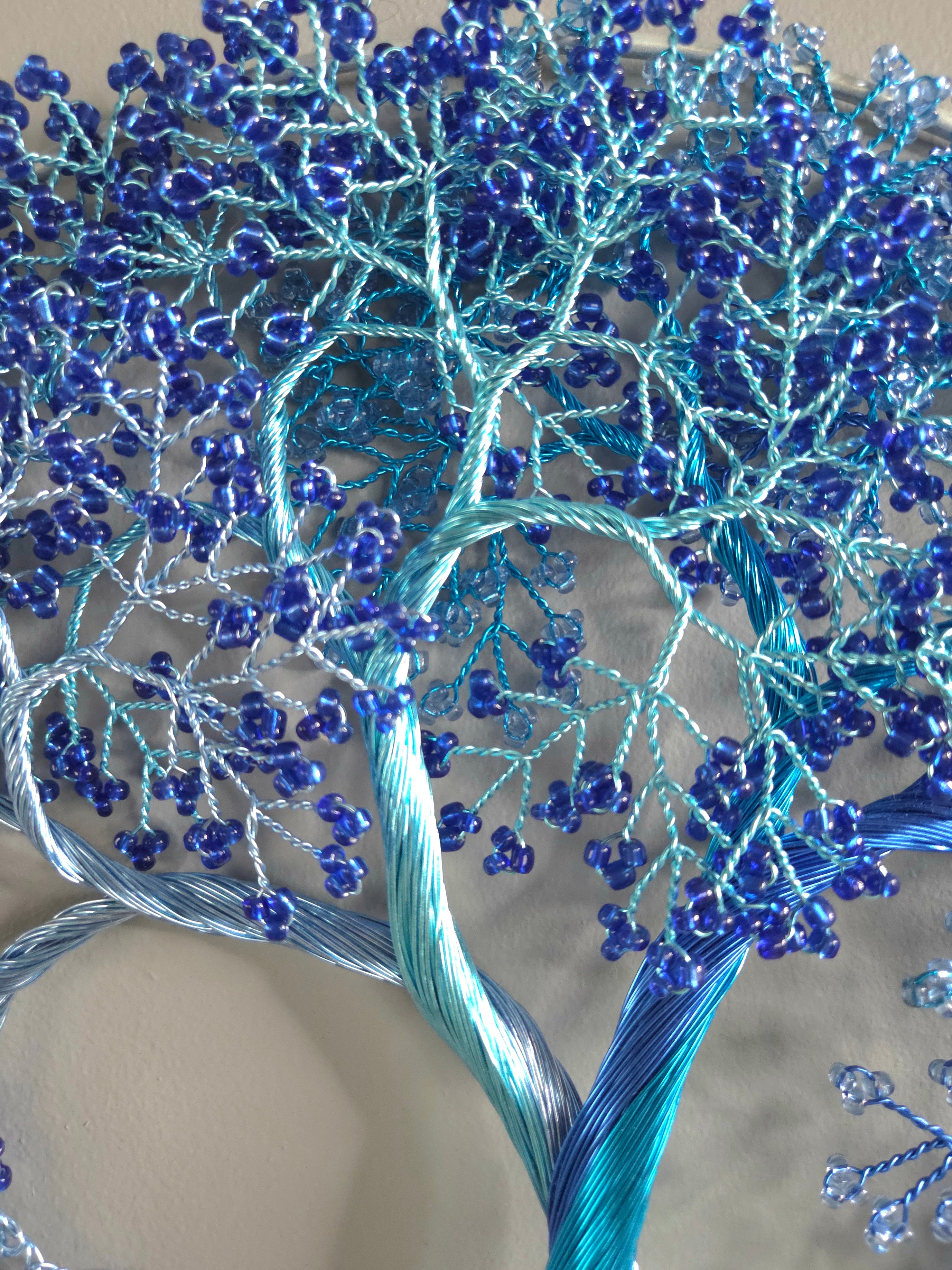 Decorative wall art of a tree with blue branches on a gray background