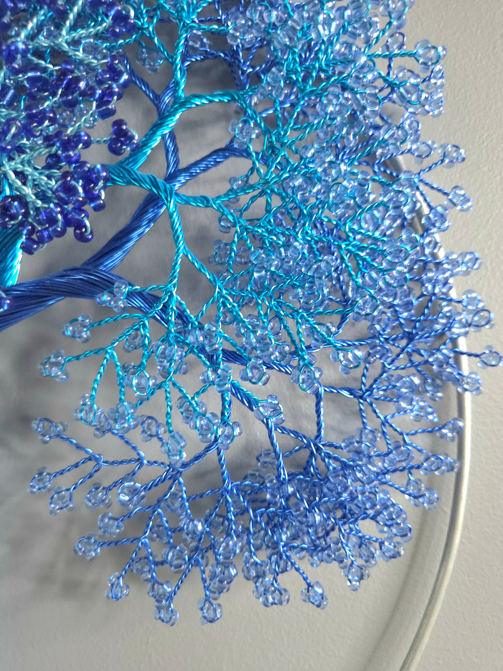 Decorative wall art of a tree with blue branches on a gray background