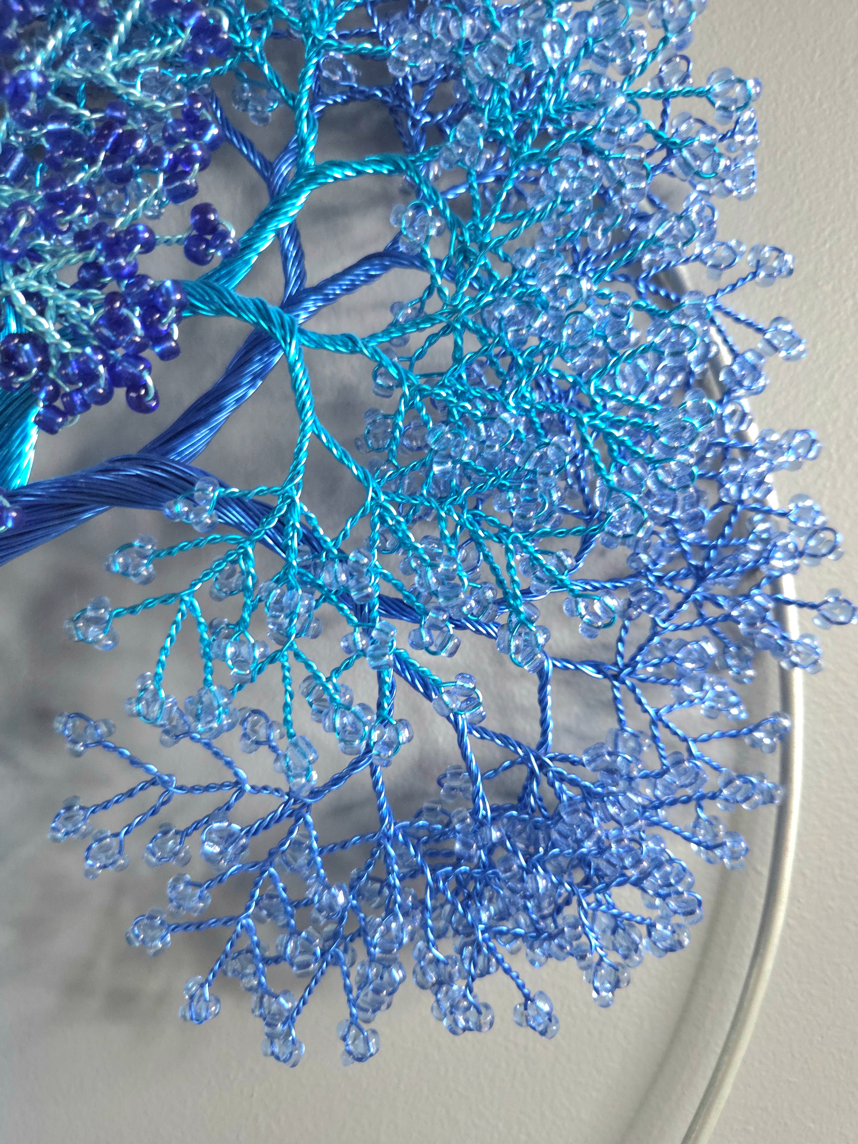 Decorative wall art of a tree with blue branches on a gray background