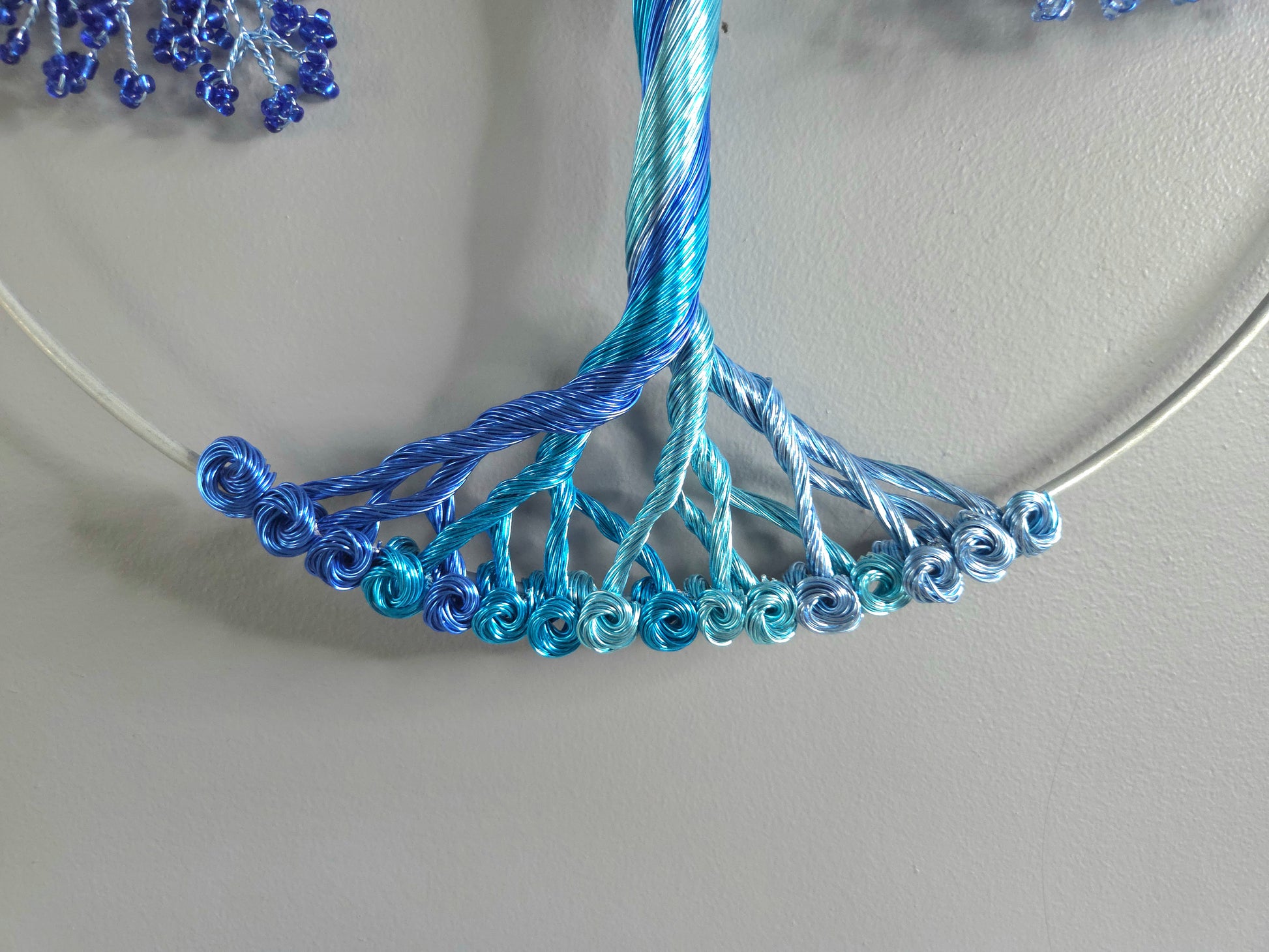 Decorative wall art of a tree with blue branches on a gray background