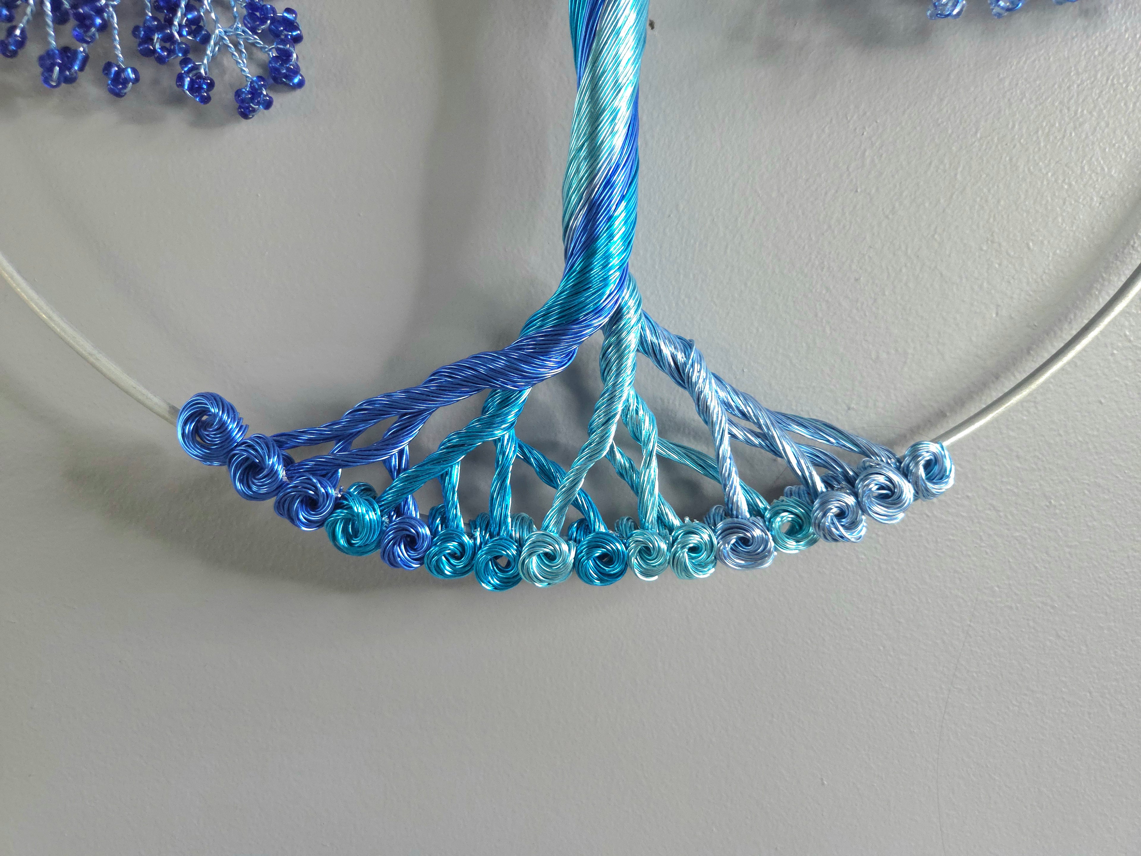 Decorative wall art of a tree with blue branches on a gray background