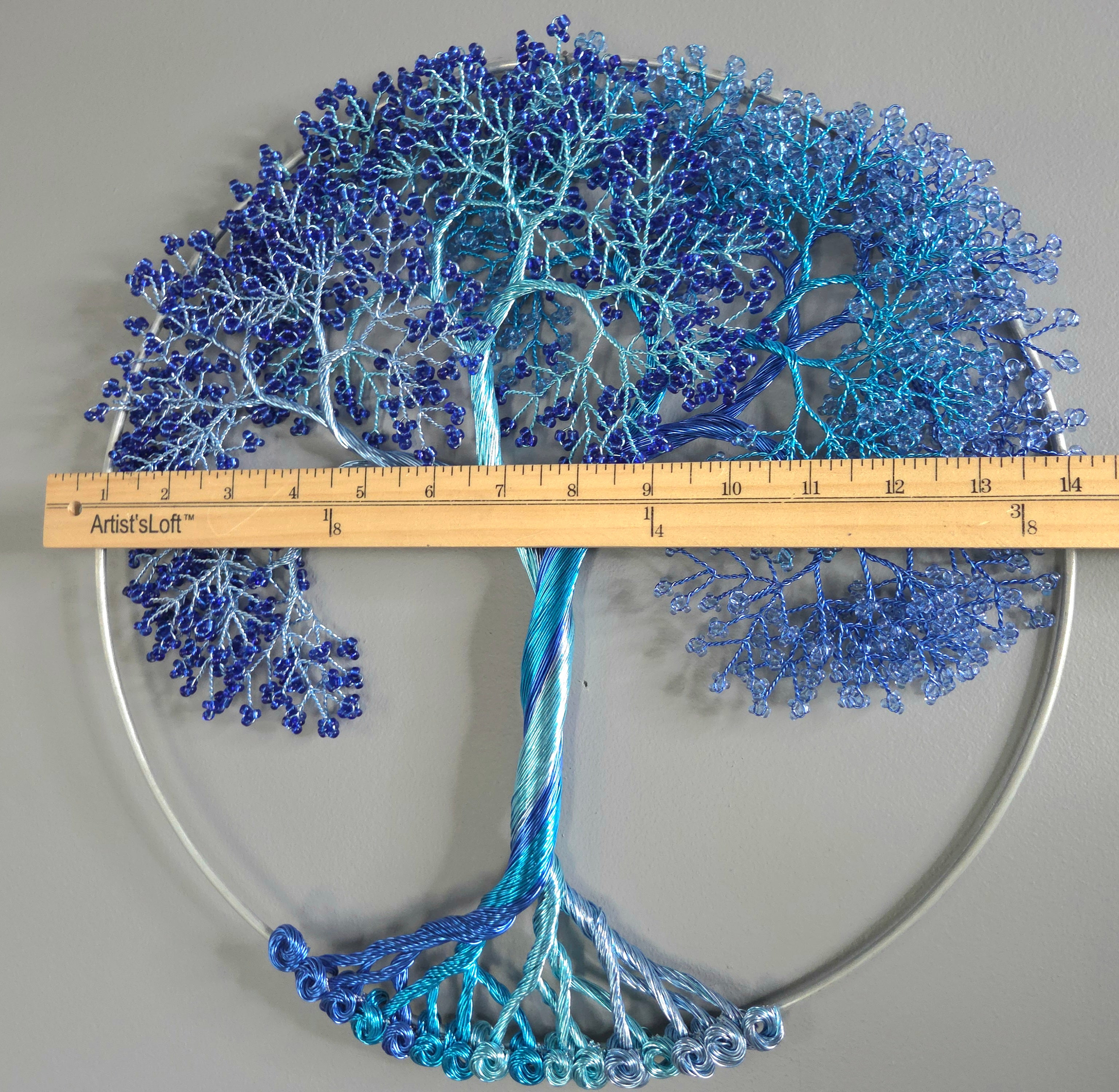 Decorative wall art of a tree with blue branches on a gray background