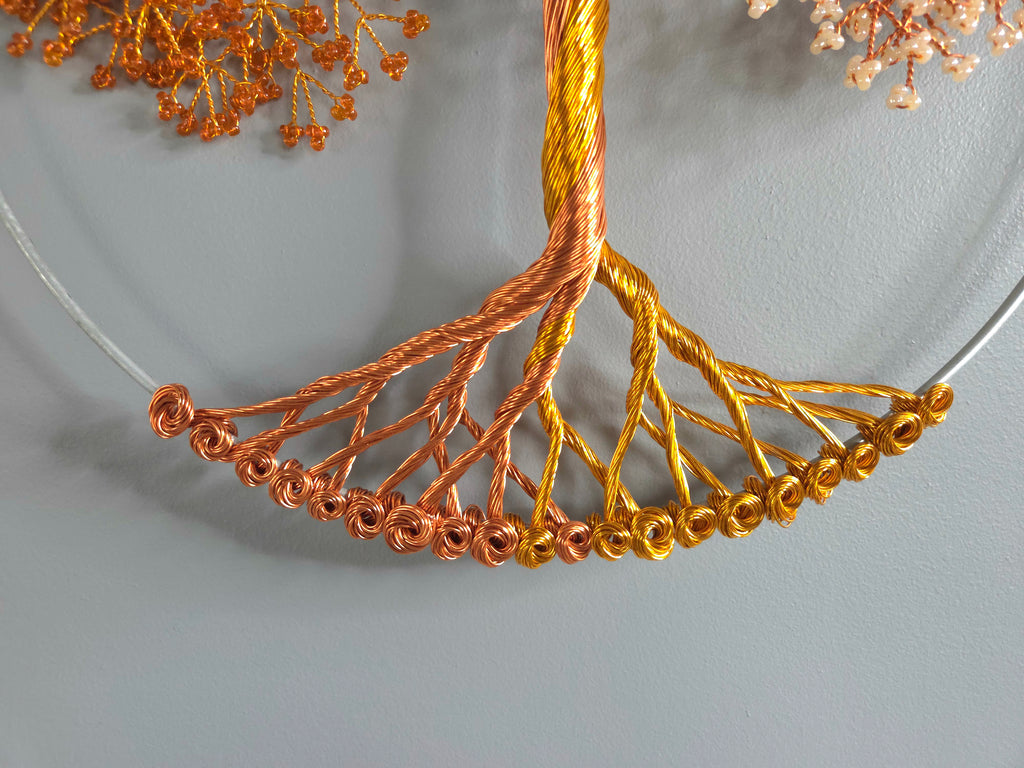 Necklace with gold and copper wire design on a gray background