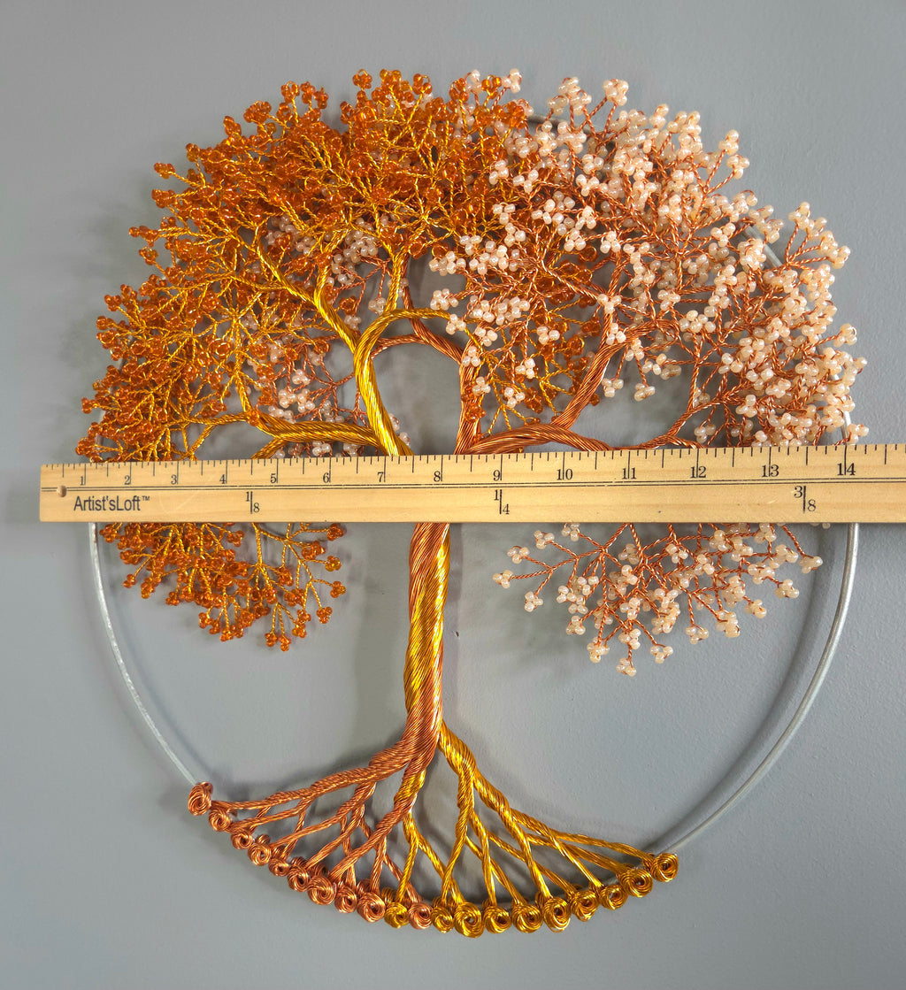 Decorative metal tree sculpture with a ruler for scale on a gray background