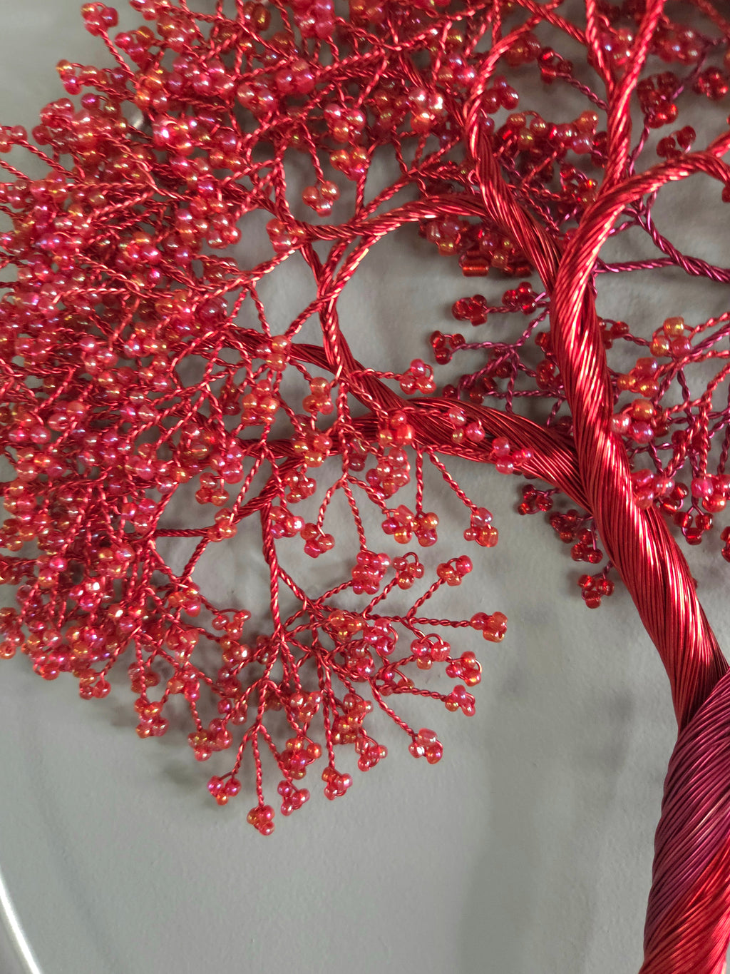 Red decorative tree with bead-like decorations on a neutral background