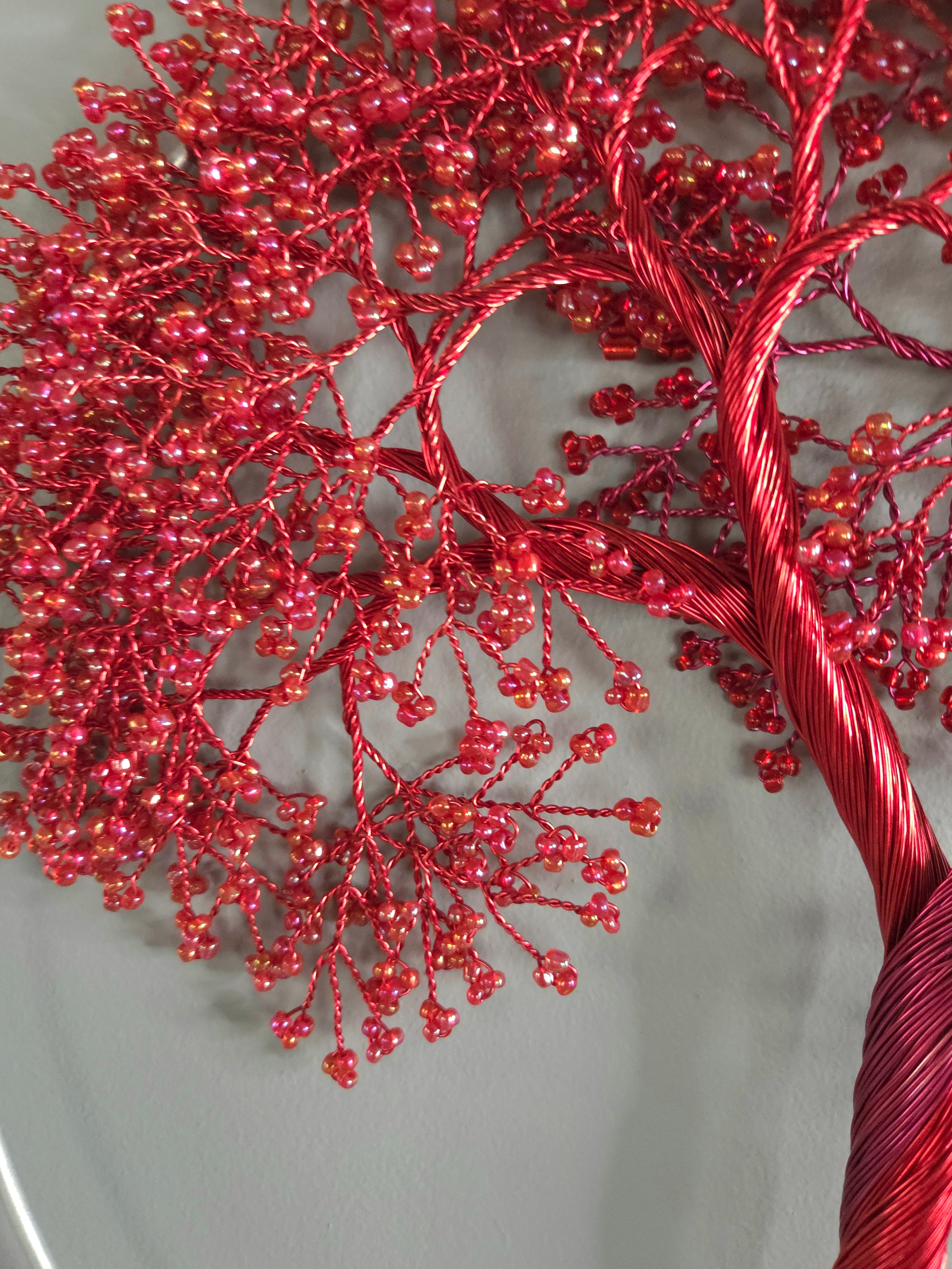 Red decorative tree with bead-like decorations on a neutral background