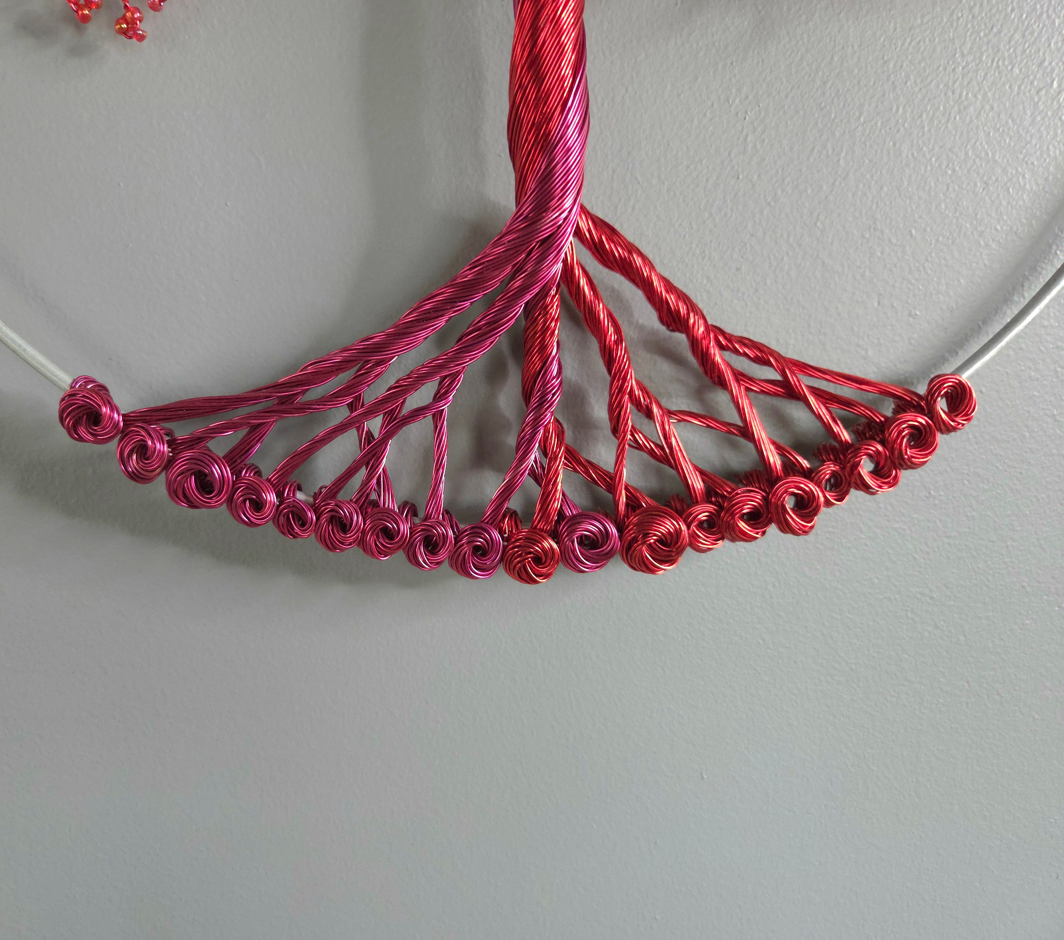 Close-up of a red wire sculpture on a gray background