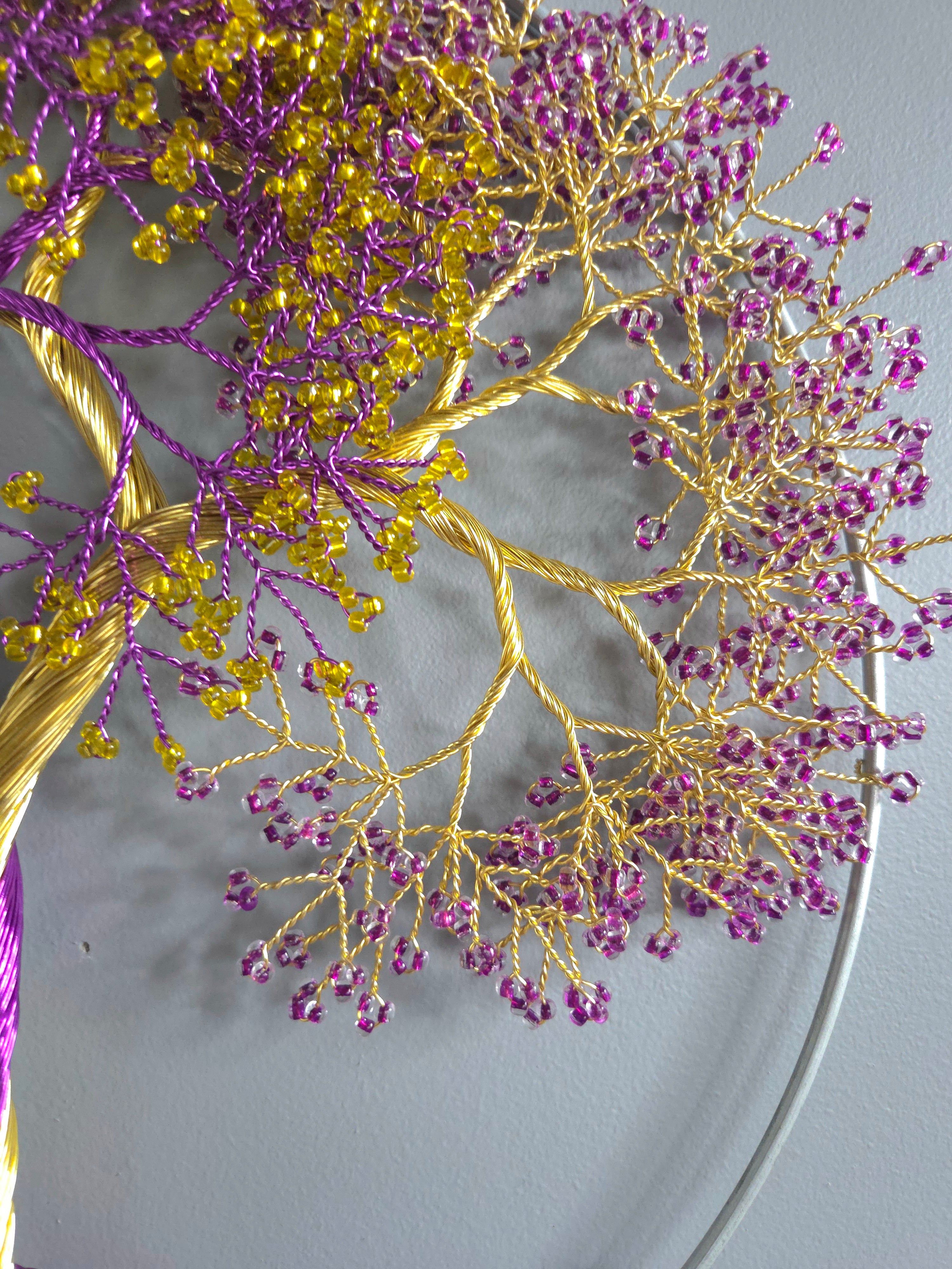 Decorative branch with purple and gold beads on a white plate