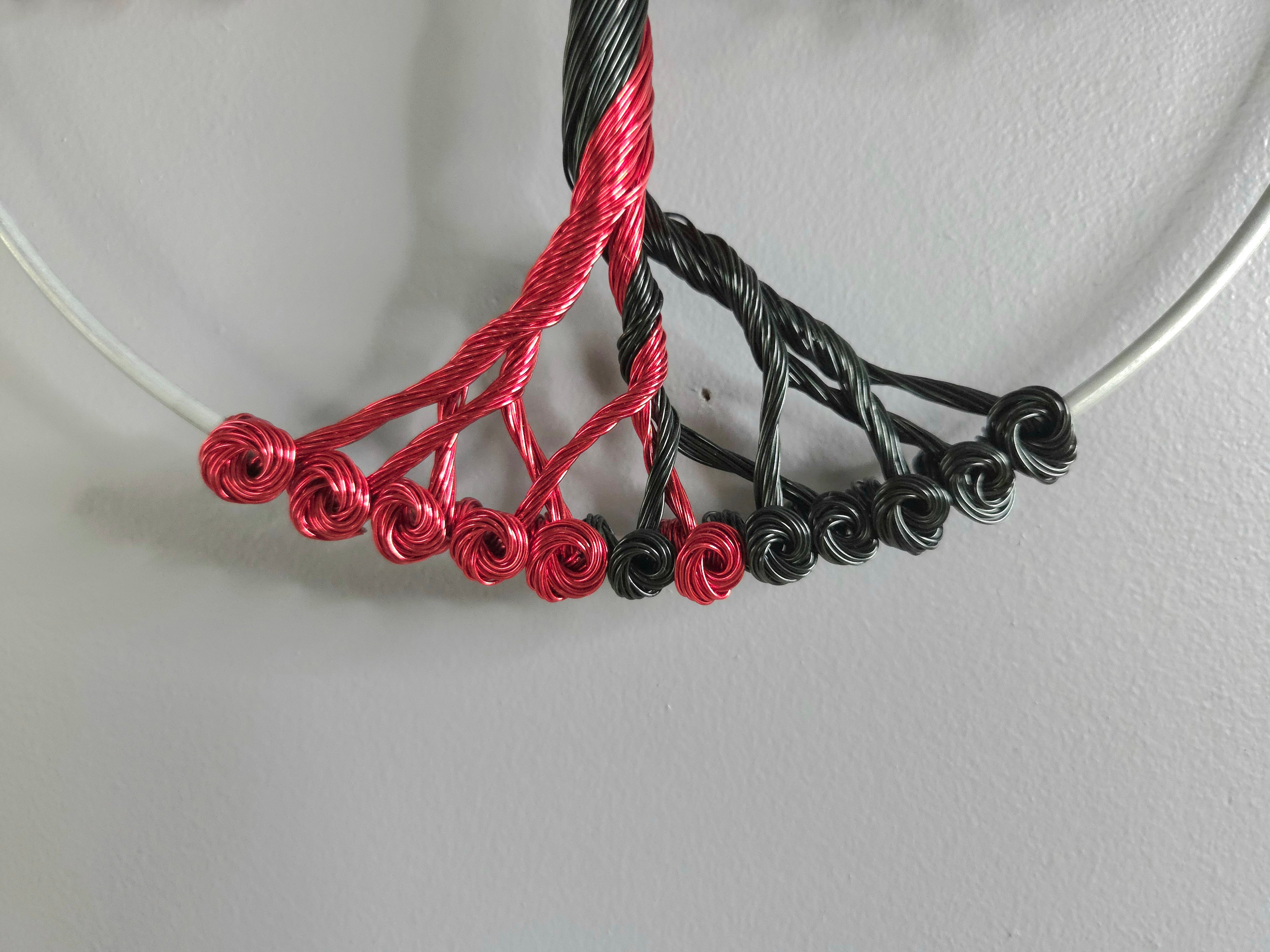 Decorative wall art of a tree with red and black branches on a gray background