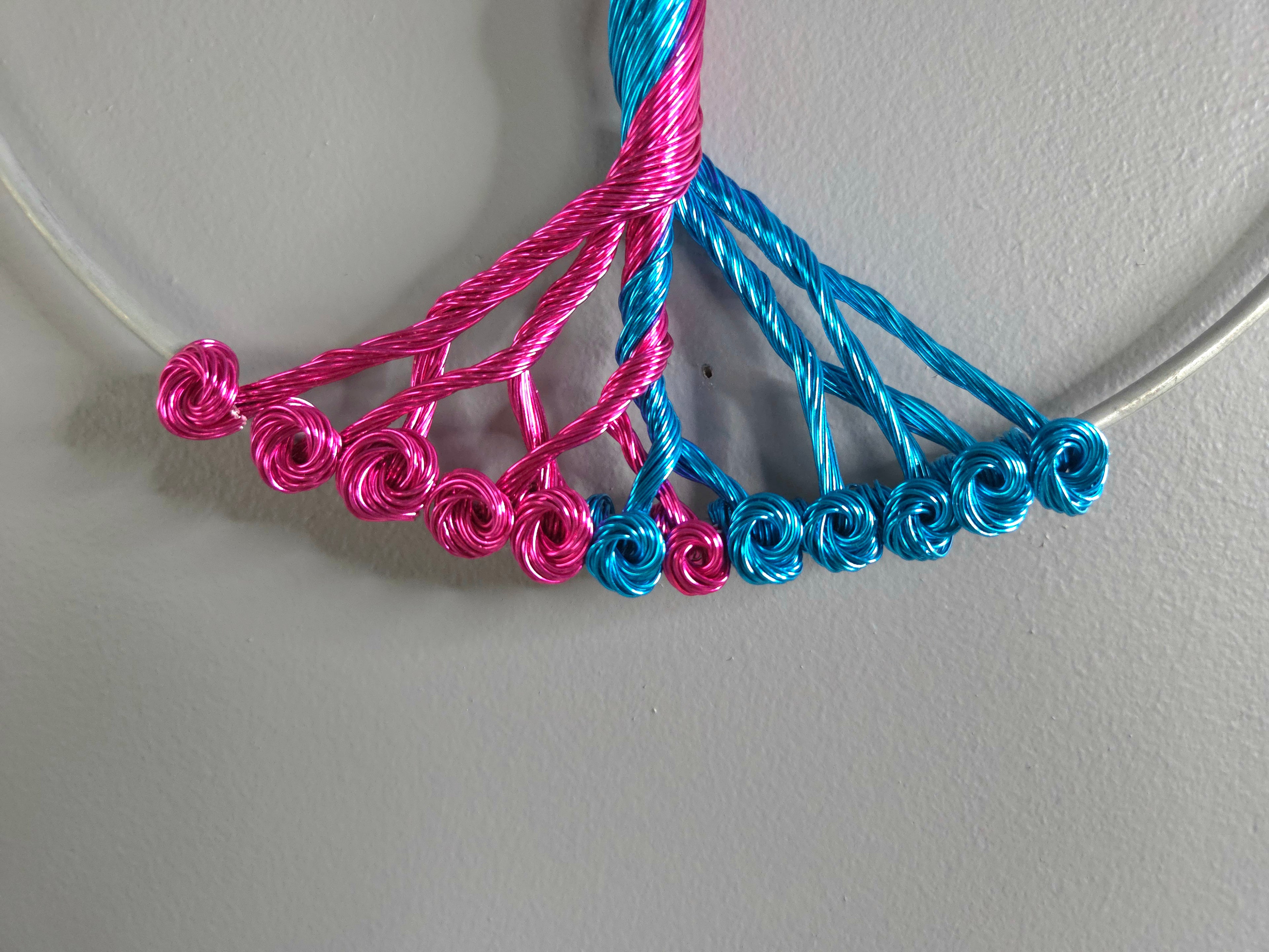 Necklace with pink and blue braided cords on a white background