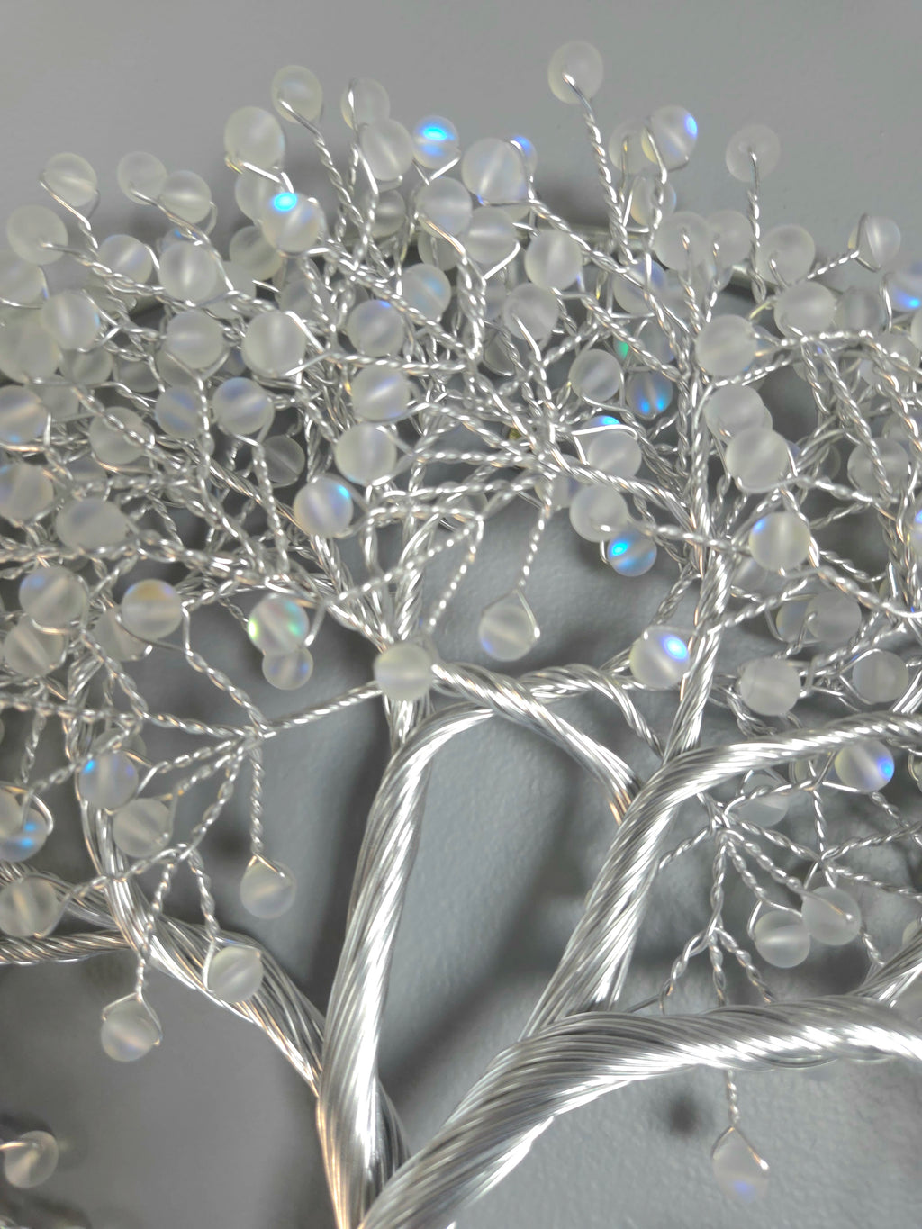 Decorative silver tree wall art on a gray background