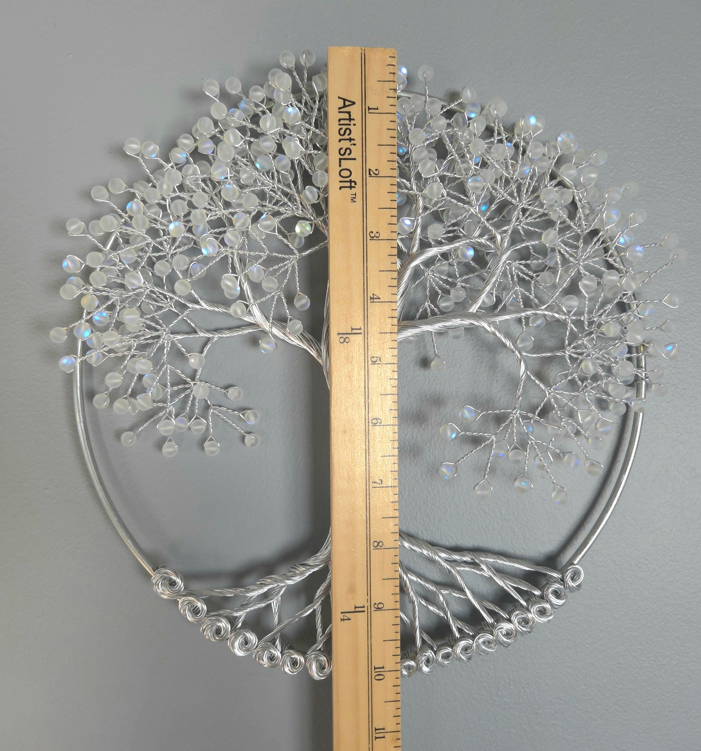 Decorative silver tree wall art on a gray background