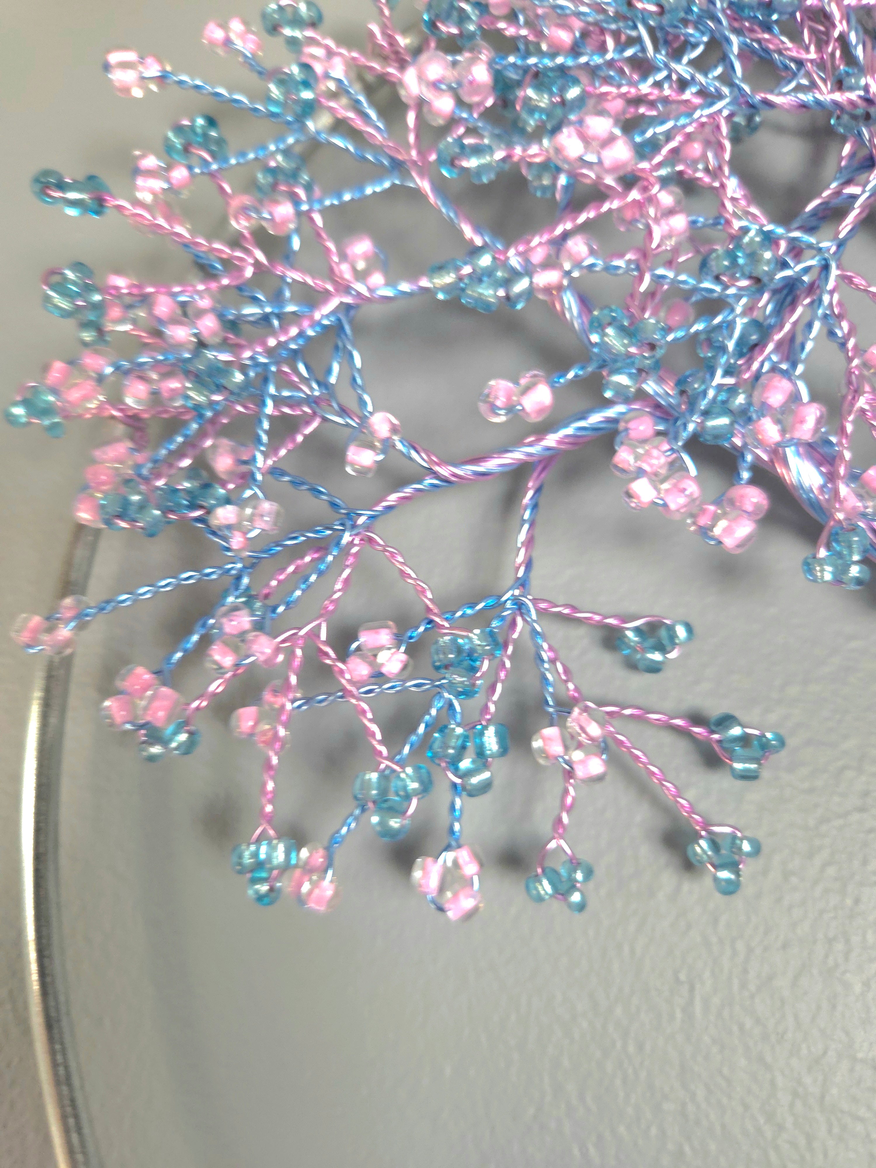 Decorative tree wall art with pink and blue branches on a gray background
