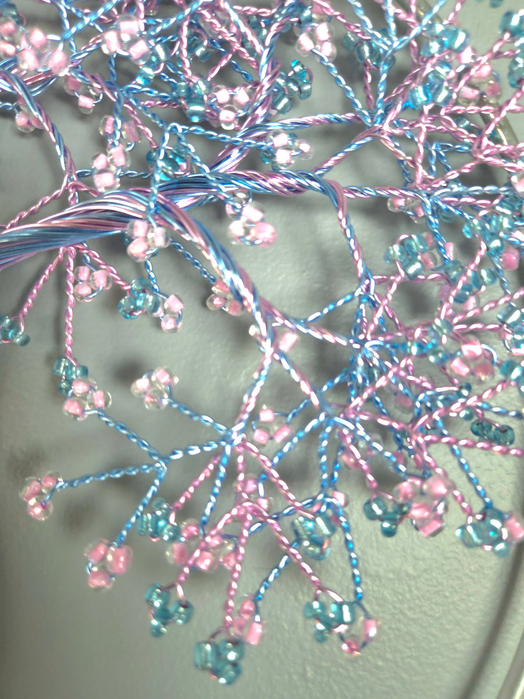 Decorative tree wall art with pink and blue branches on a gray background