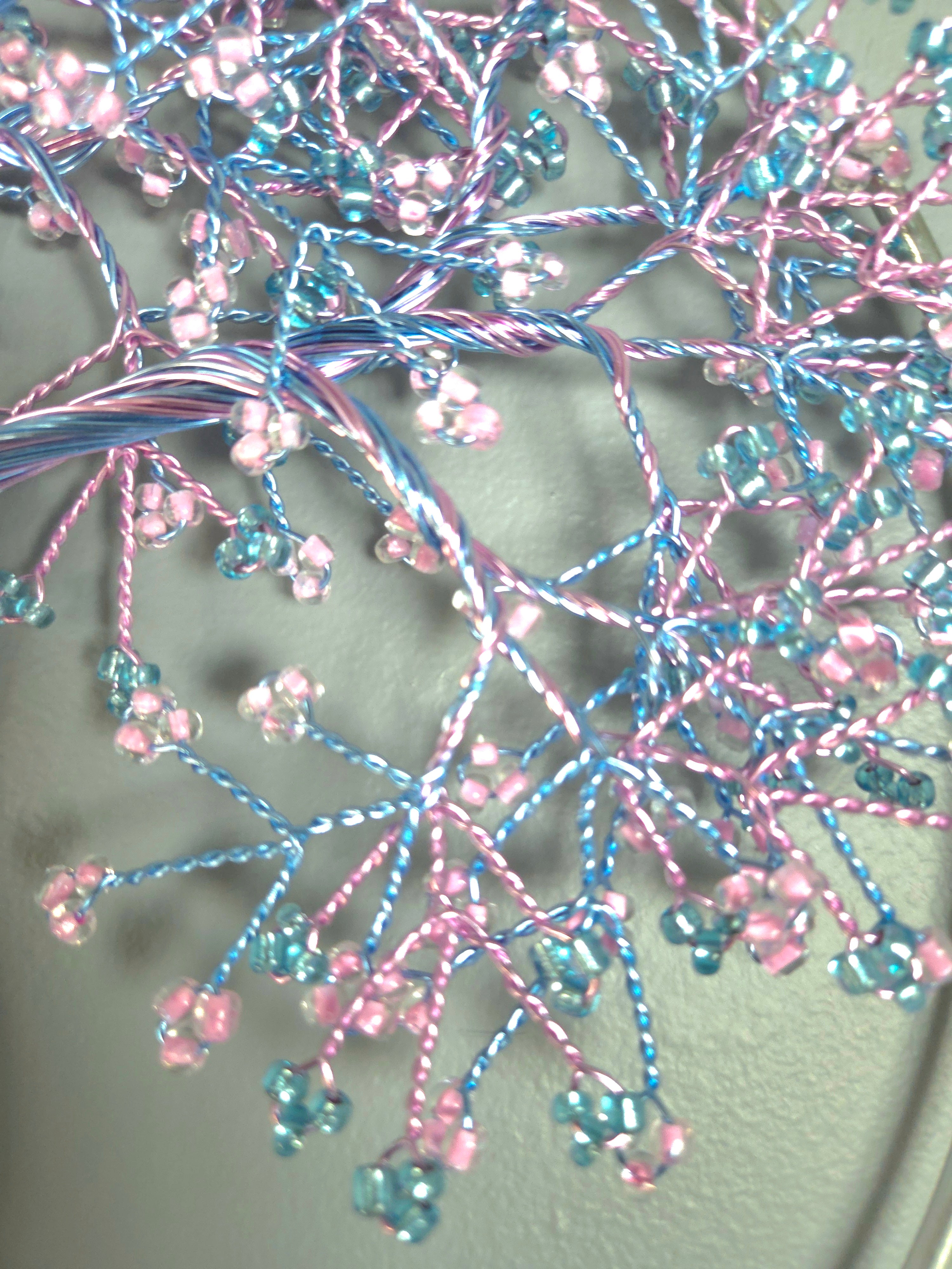 Decorative tree wall art with pink and blue branches on a gray background