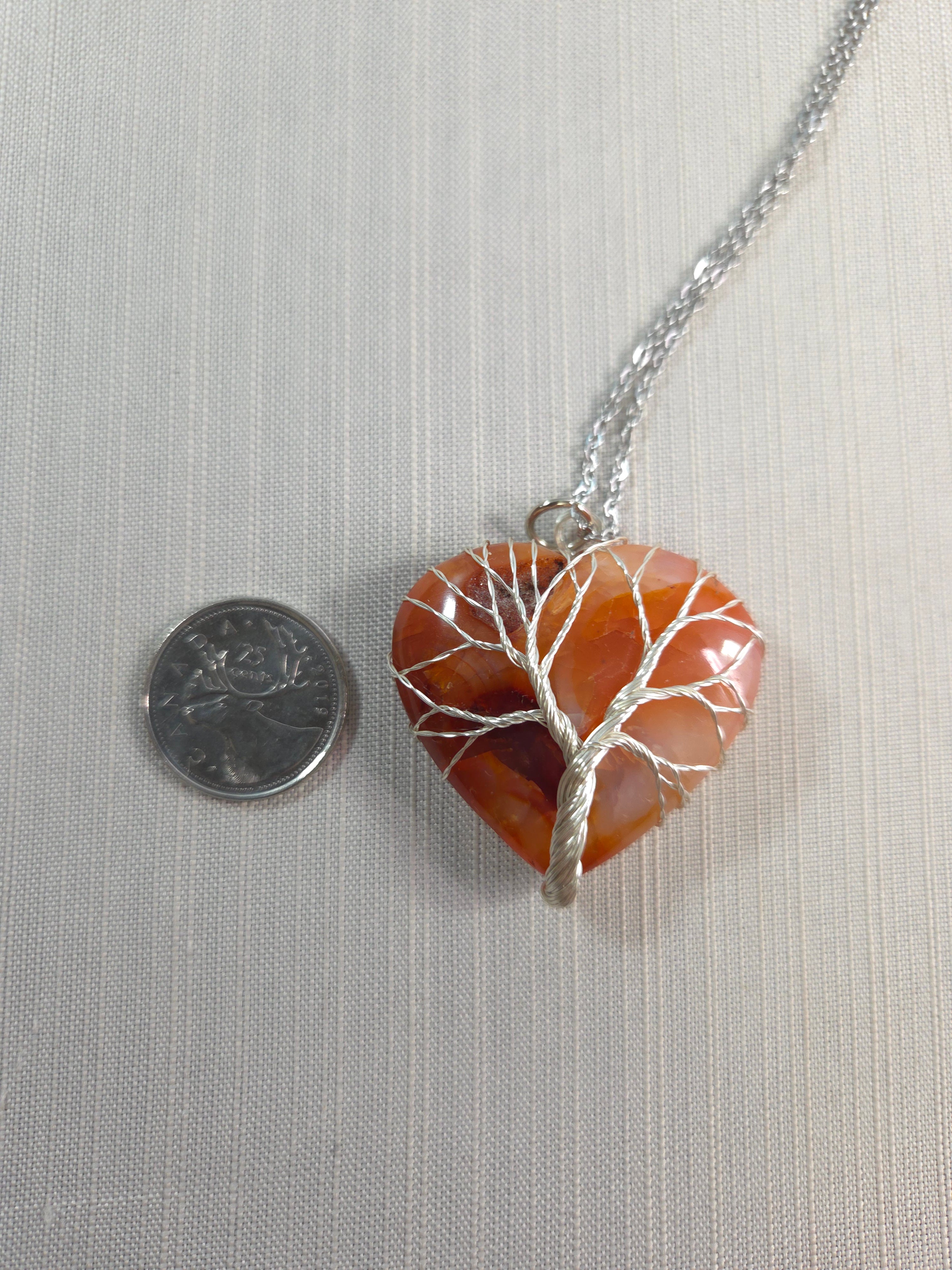 Heart-shaped stone pendant with silver chain on a light gray background