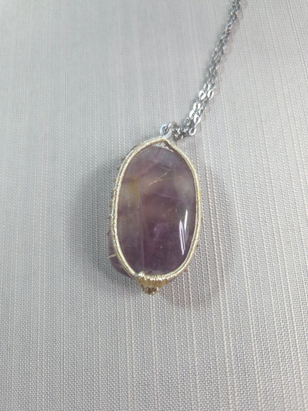 Necklace with a purple stone pendant on a light gray background
