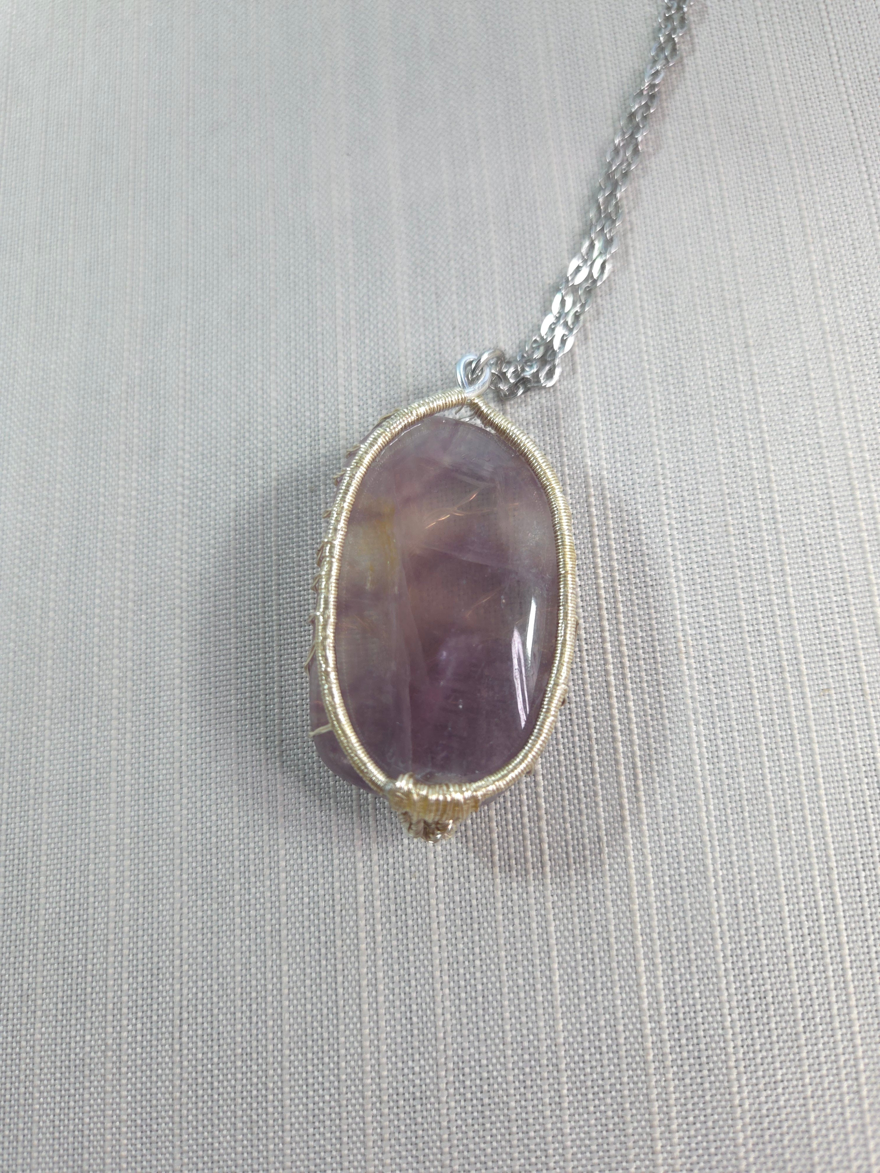 Necklace with a purple stone pendant on a light gray background