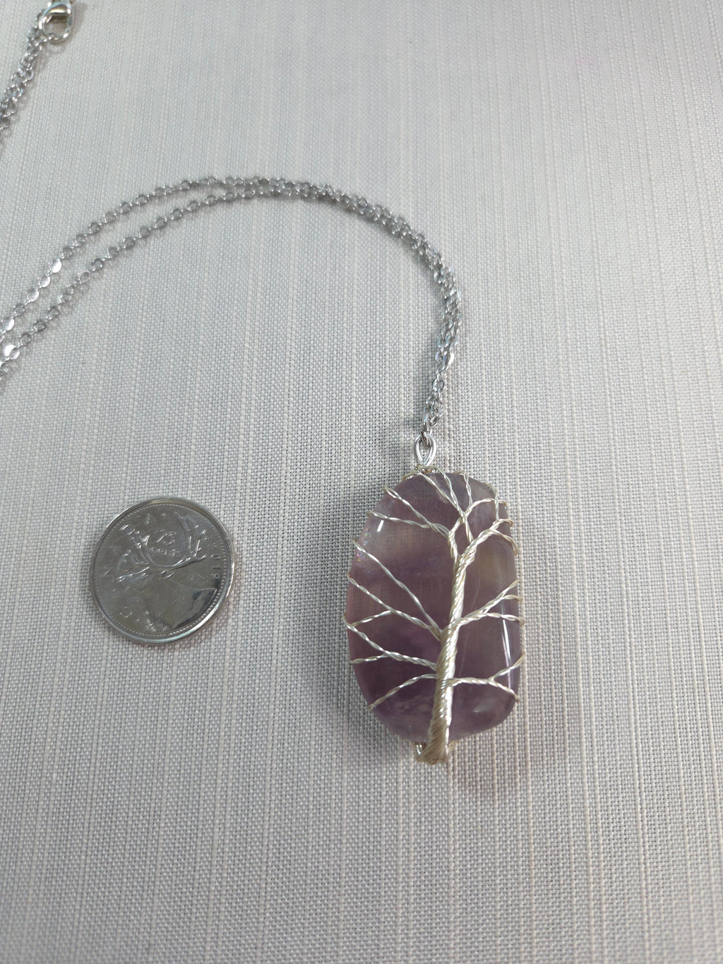Necklace with a purple stone pendant on a light gray background