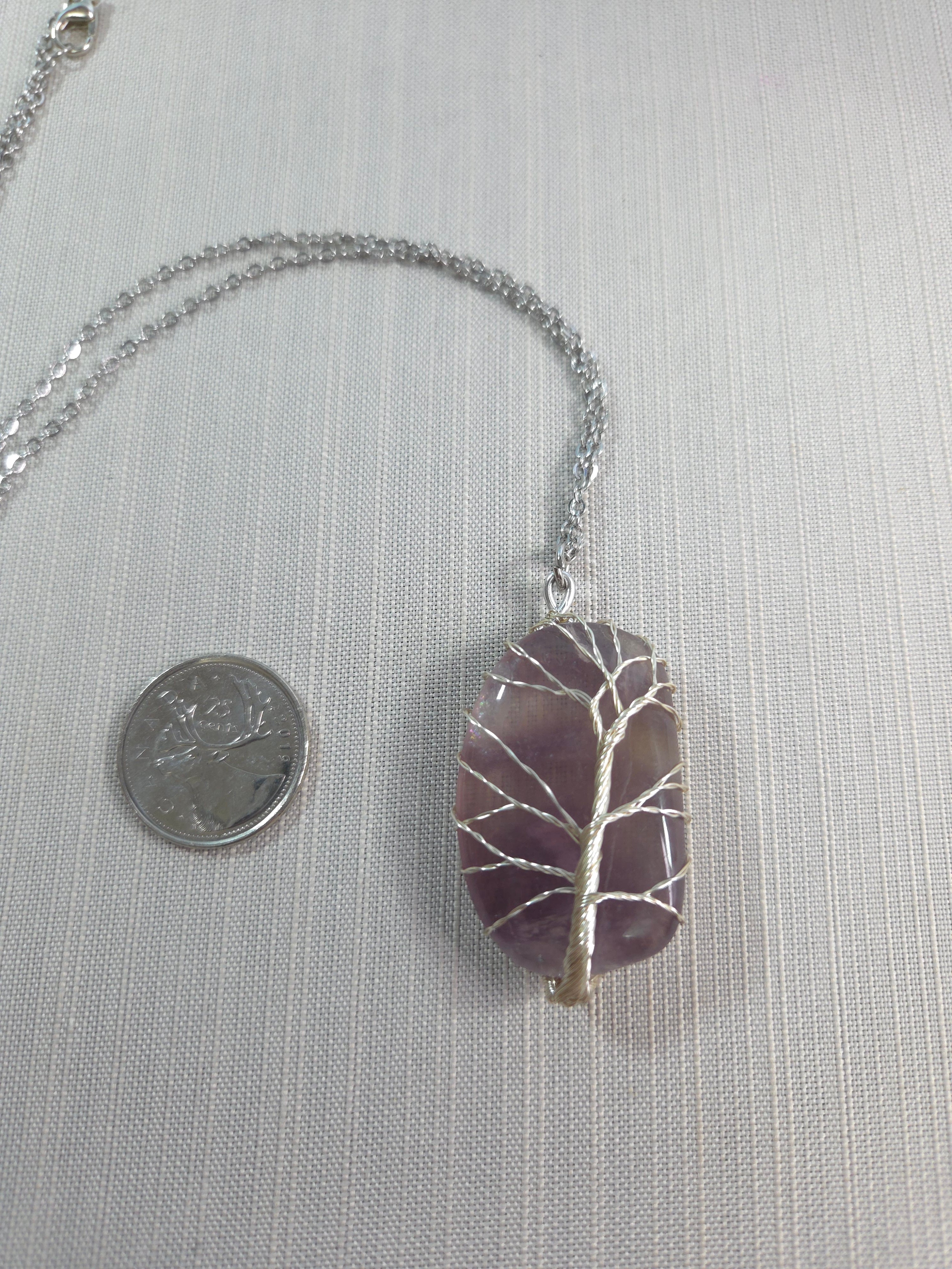 Necklace with a purple stone pendant on a light gray background