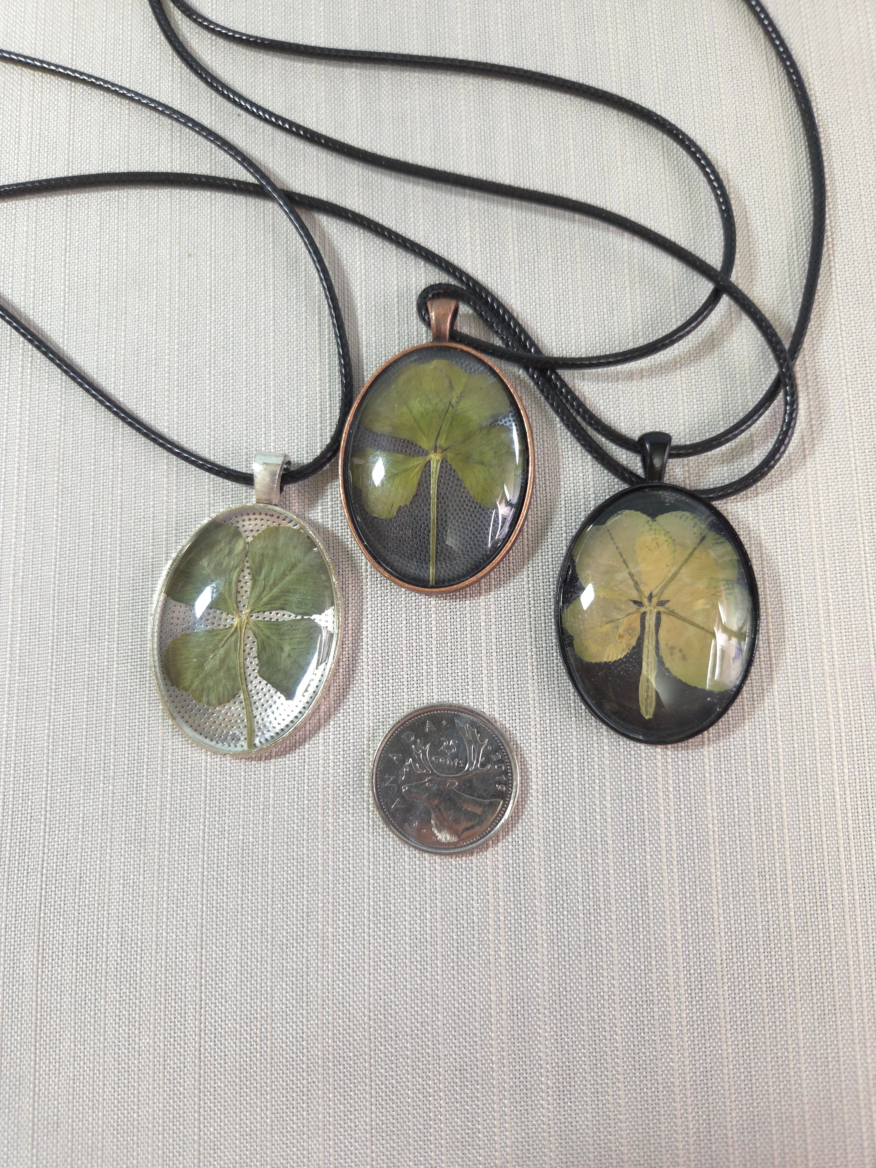 Three pendants with leaf designs on a textured surface