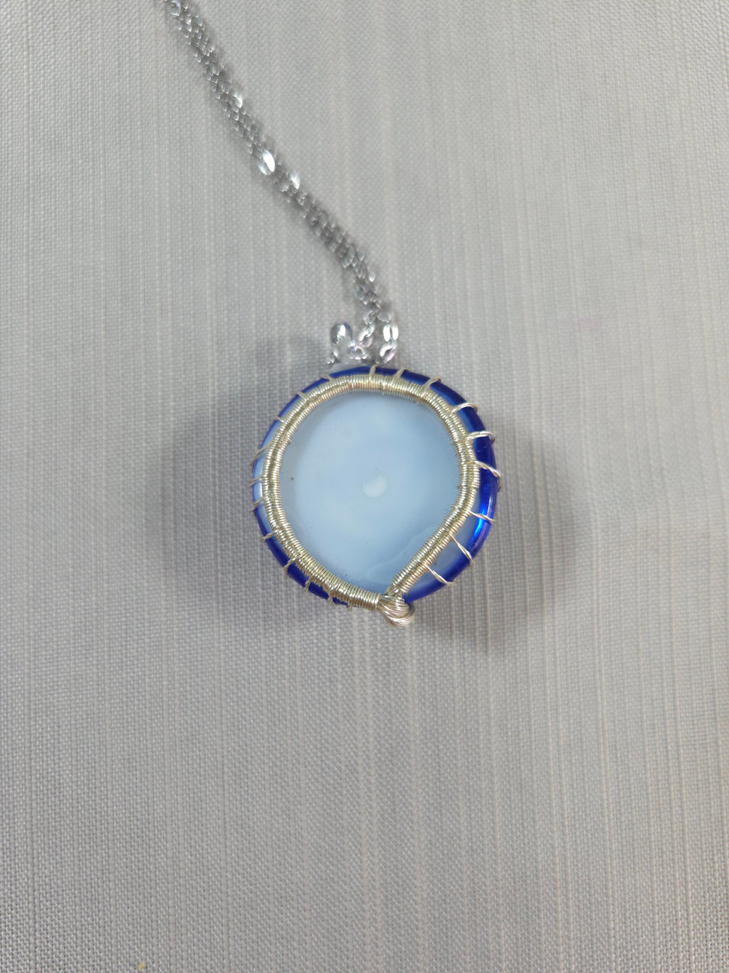 Necklace with a blue pendant on a gray background