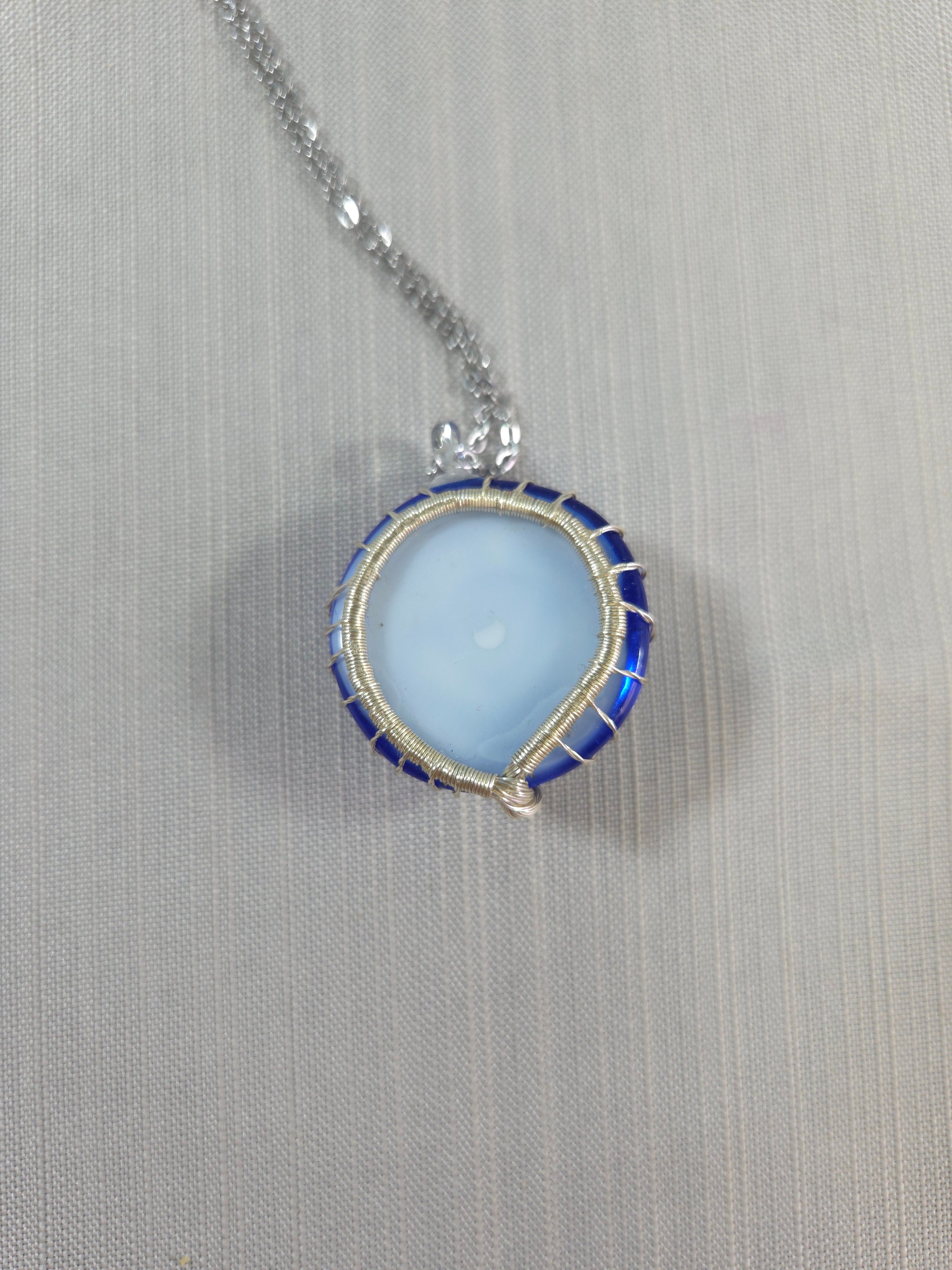 Necklace with a blue pendant on a gray background
