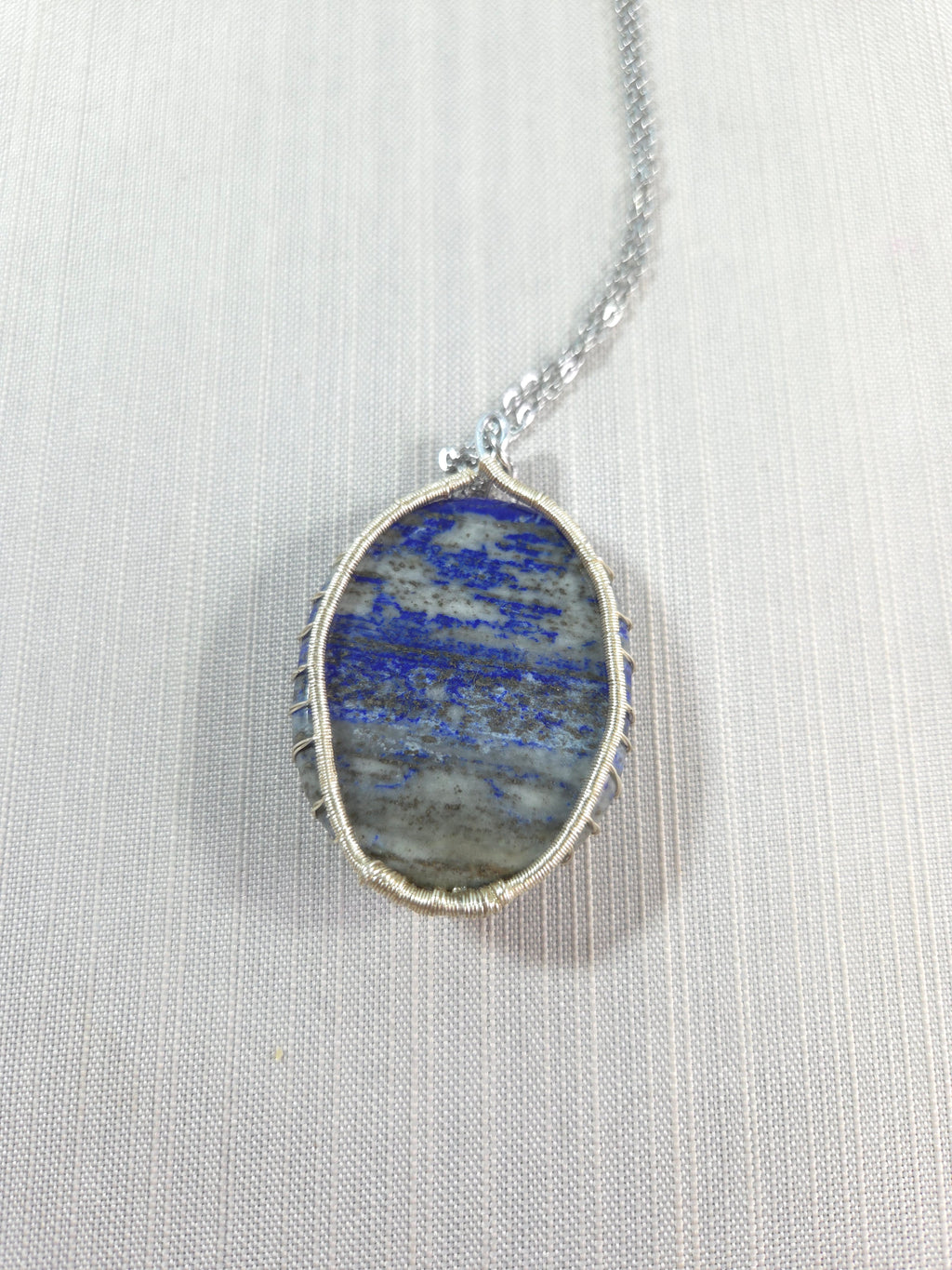 Necklace with a blue stone pendant on a white background