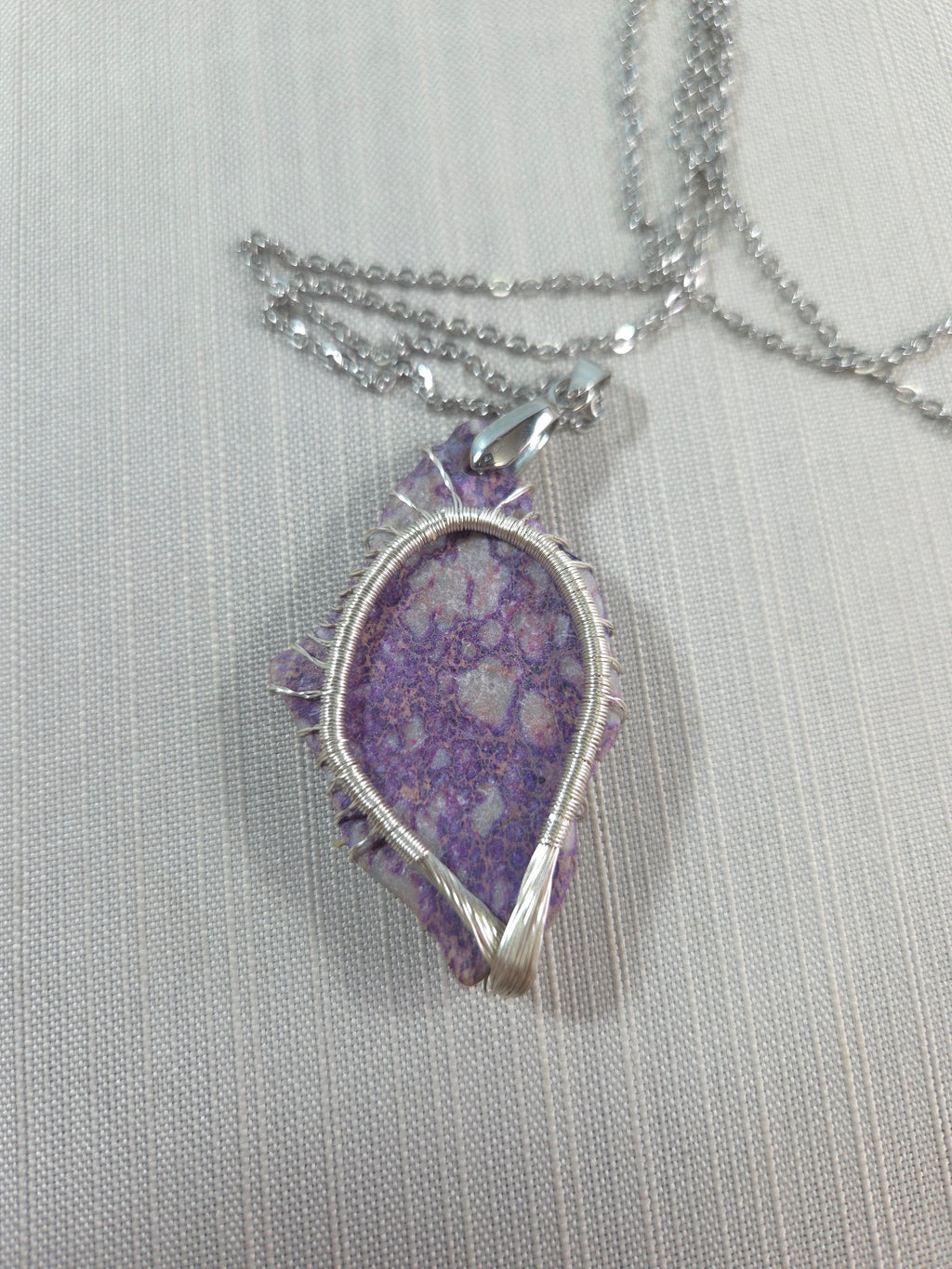 Necklace with a purple pendant on a light gray background