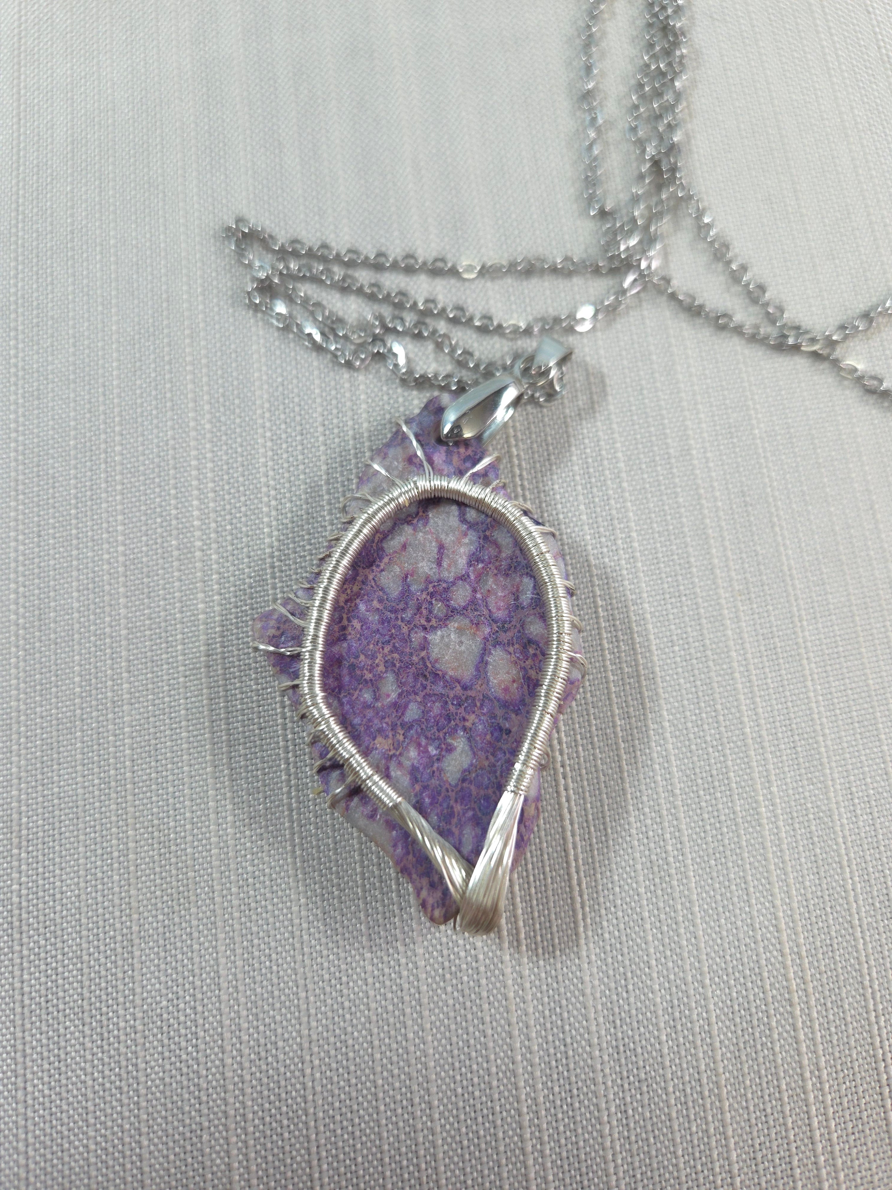 Necklace with a purple pendant on a light gray background