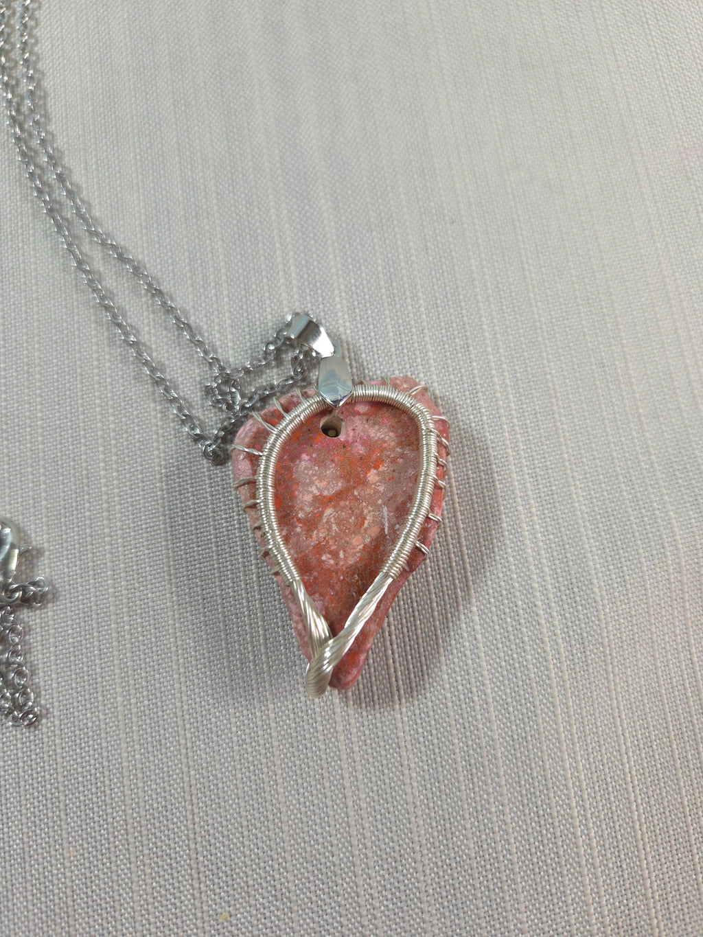 Necklace with a pink stone pendant on a light gray background