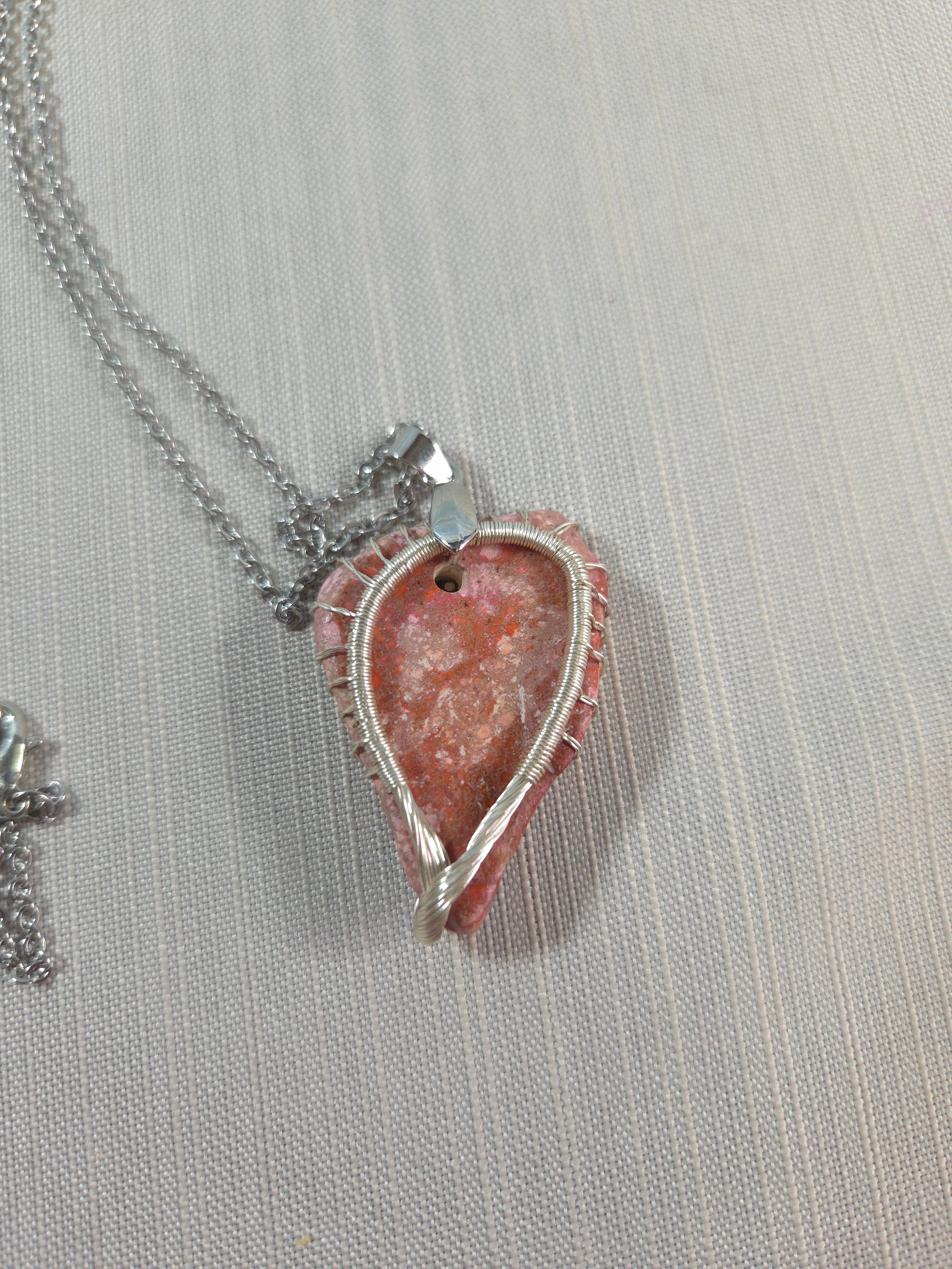 Necklace with a pink stone pendant on a light gray background
