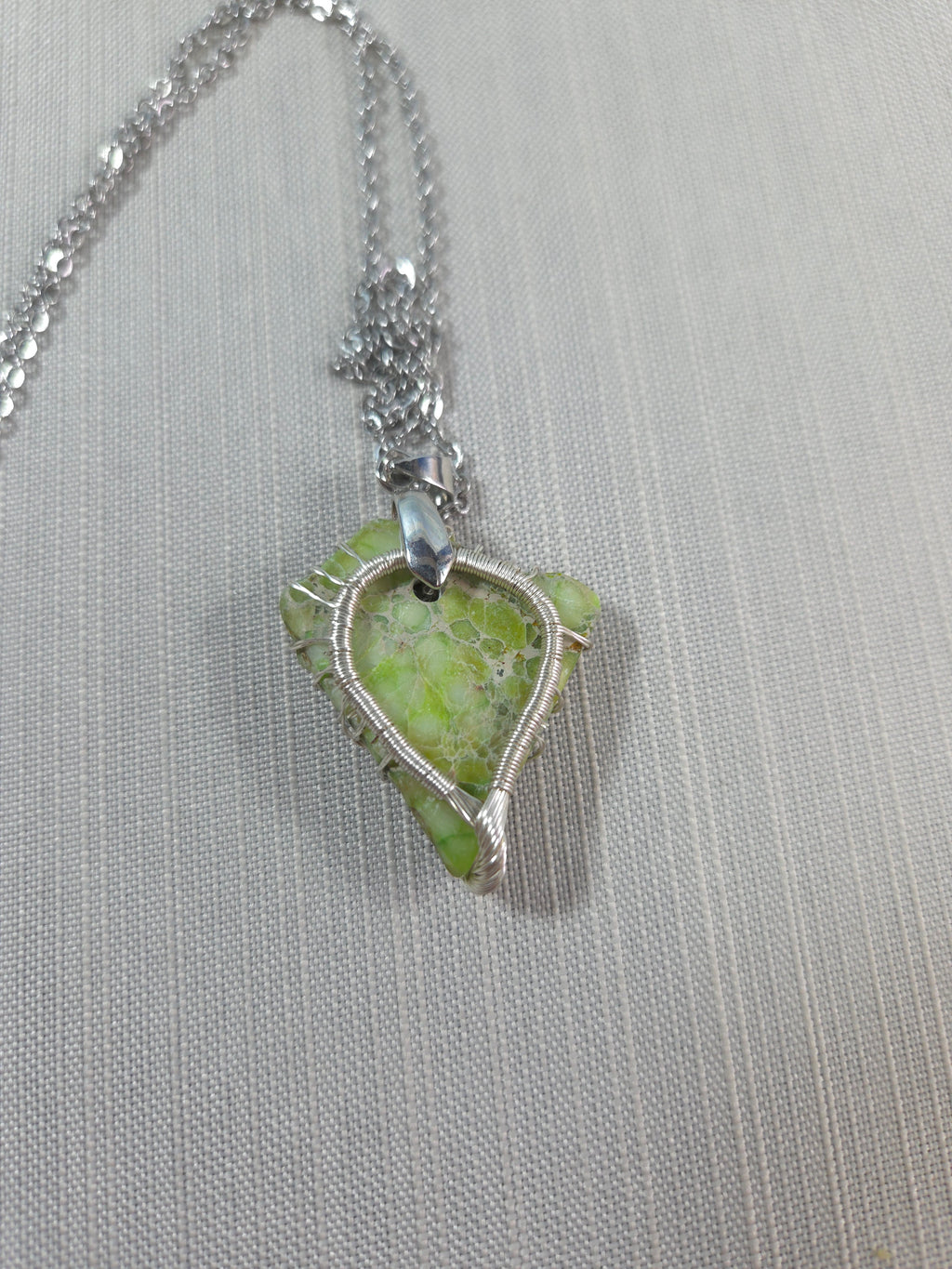 Necklace with a green pendant on a gray background