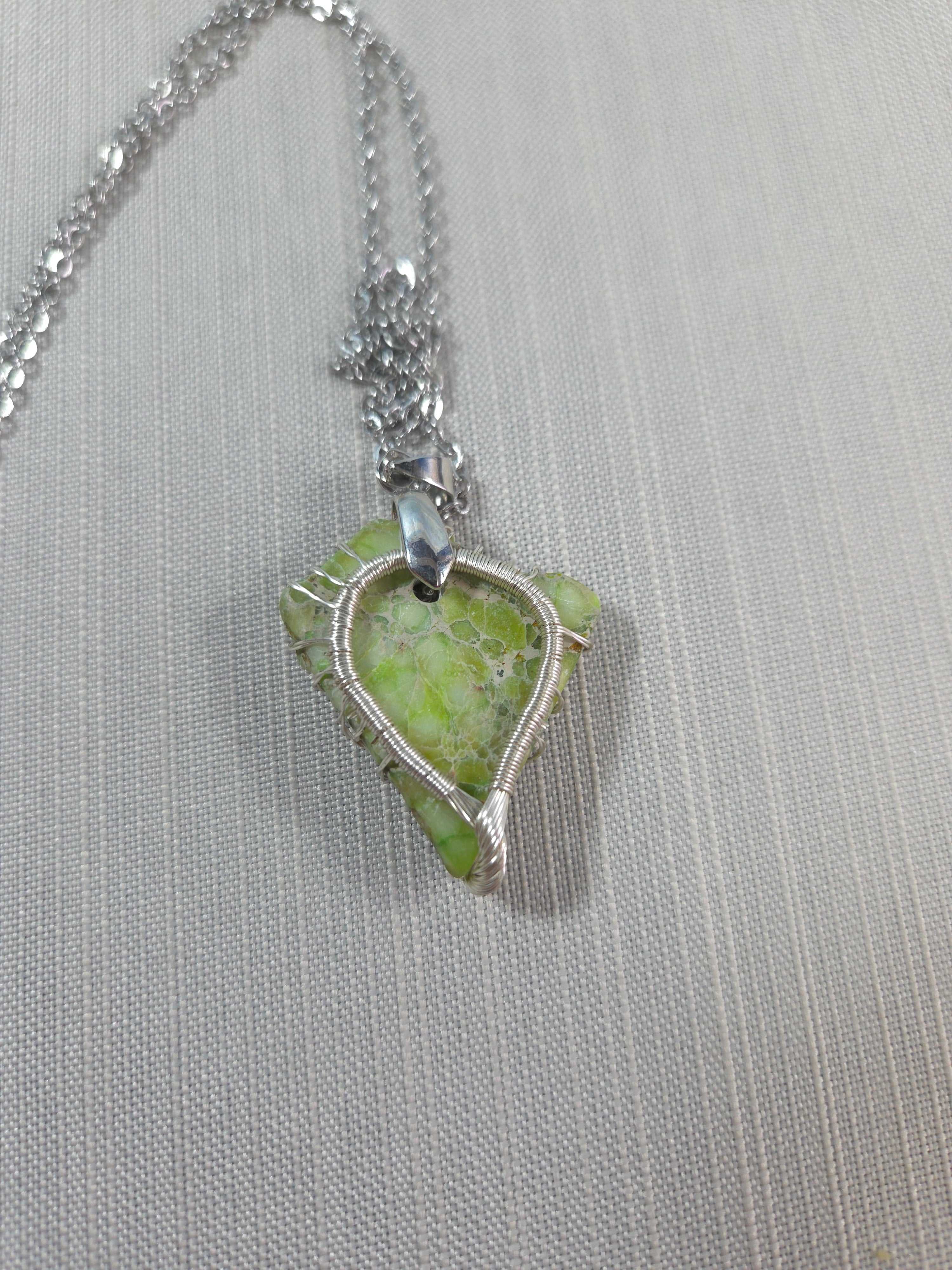 Necklace with a green pendant on a gray background