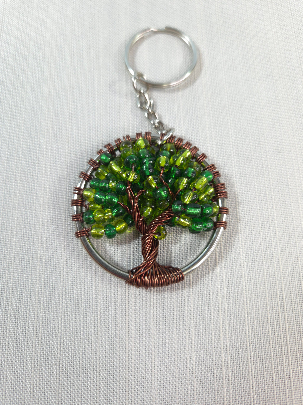 Keychain with green beaded design on a white background