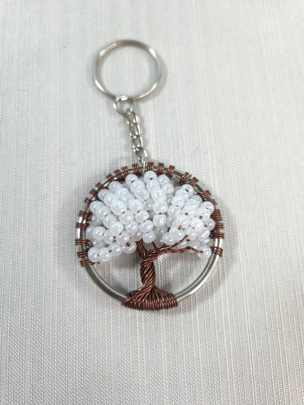 Keychain with beaded tree design on a white background